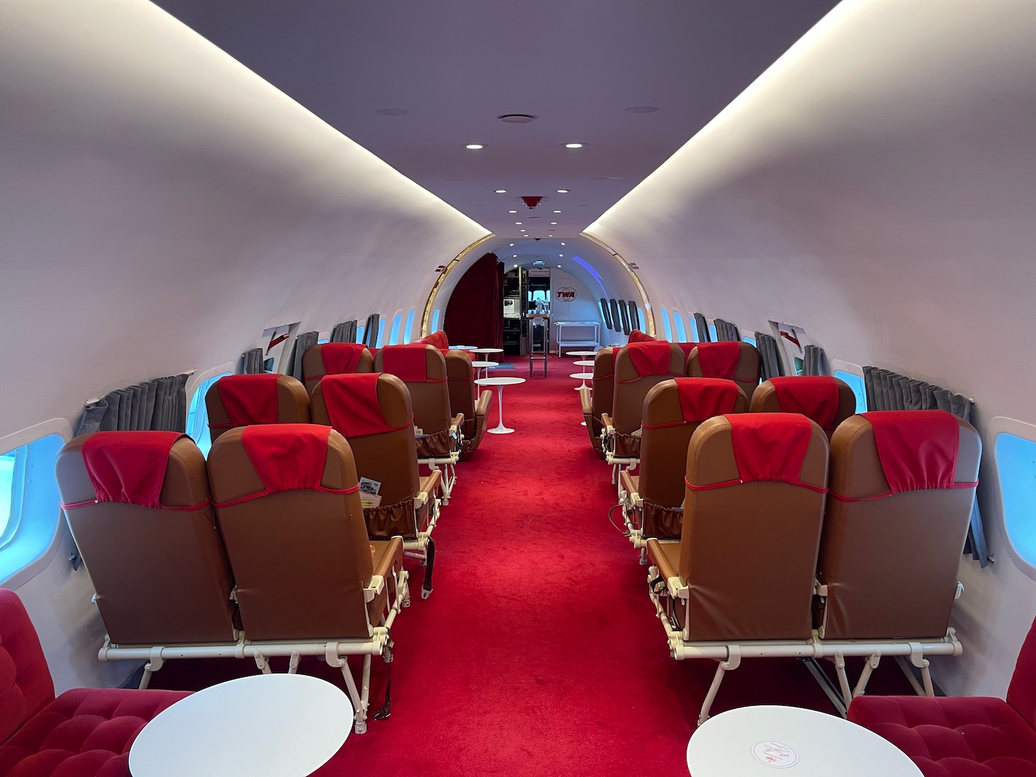 a red carpeted room with chairs and tables