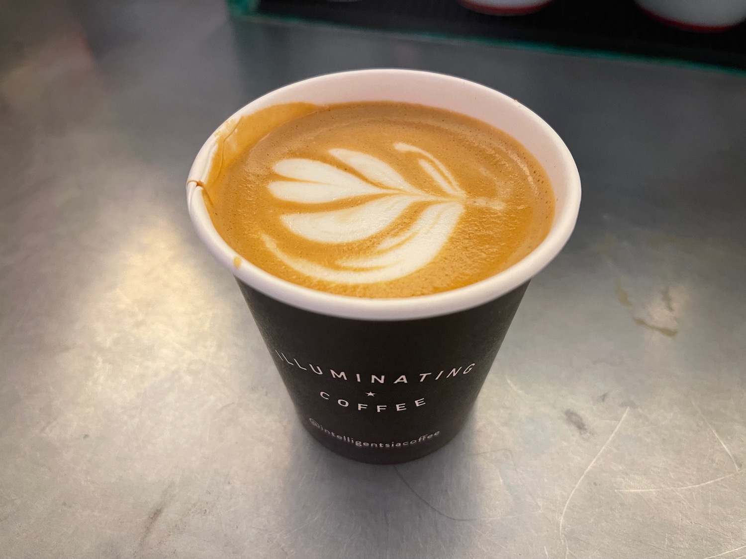 a cup of coffee with a leaf design in it