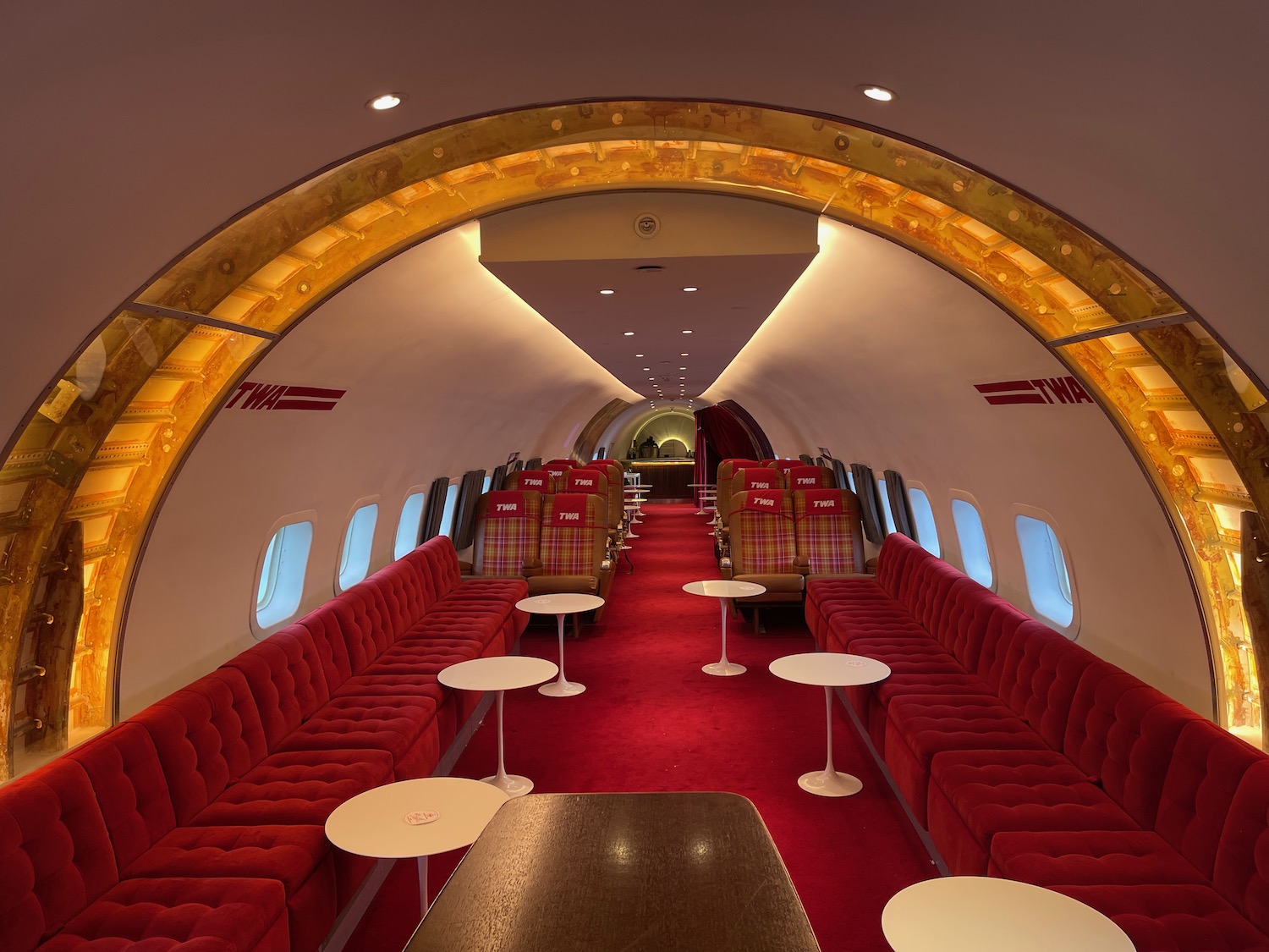 a red and white airplane with tables and chairs