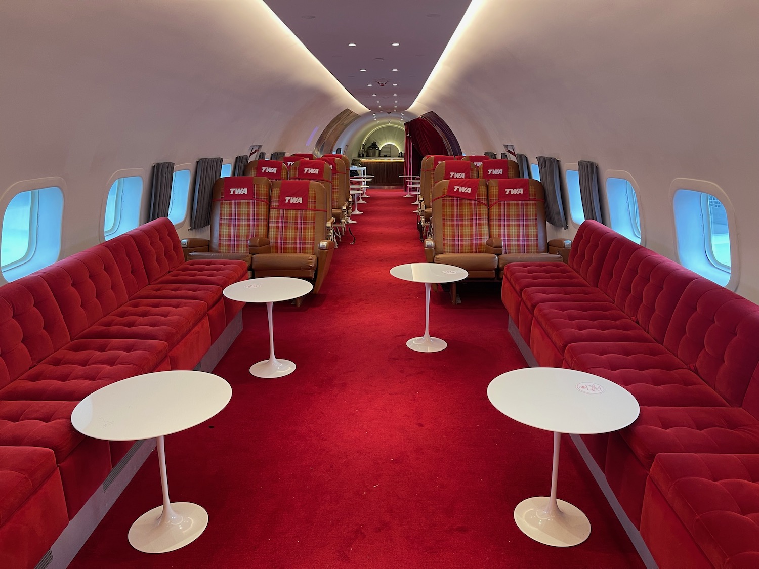 a red carpeted room with chairs and tables