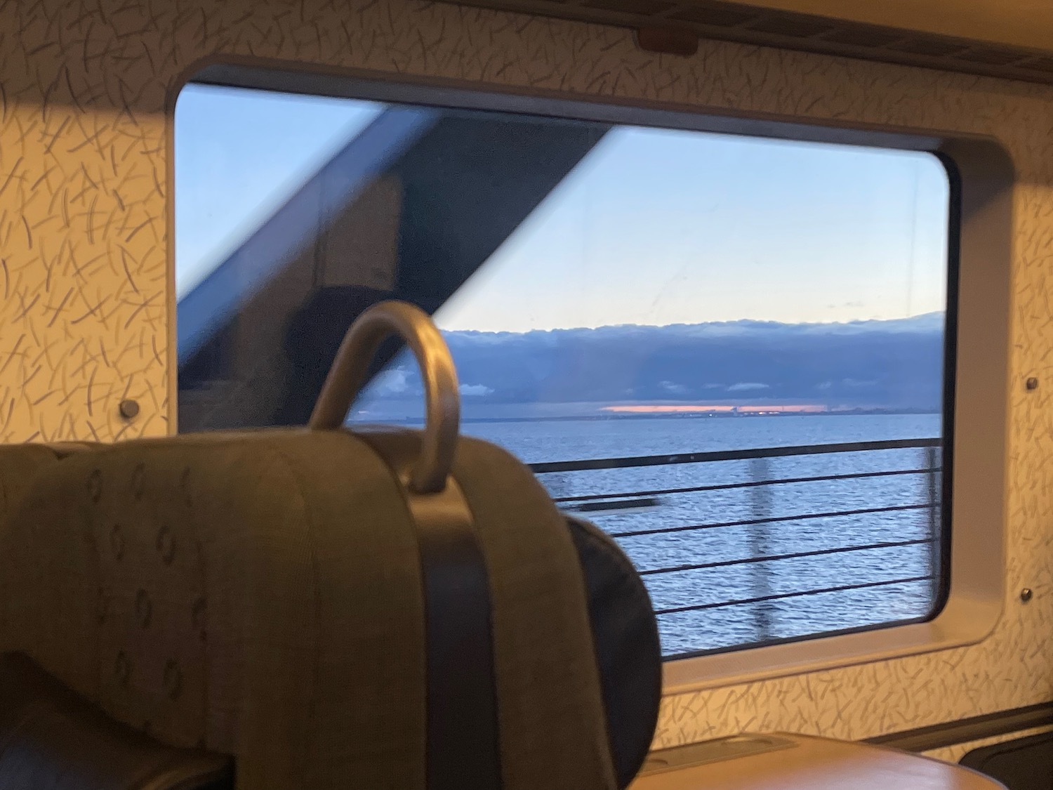 a window with a view of the ocean and mountains