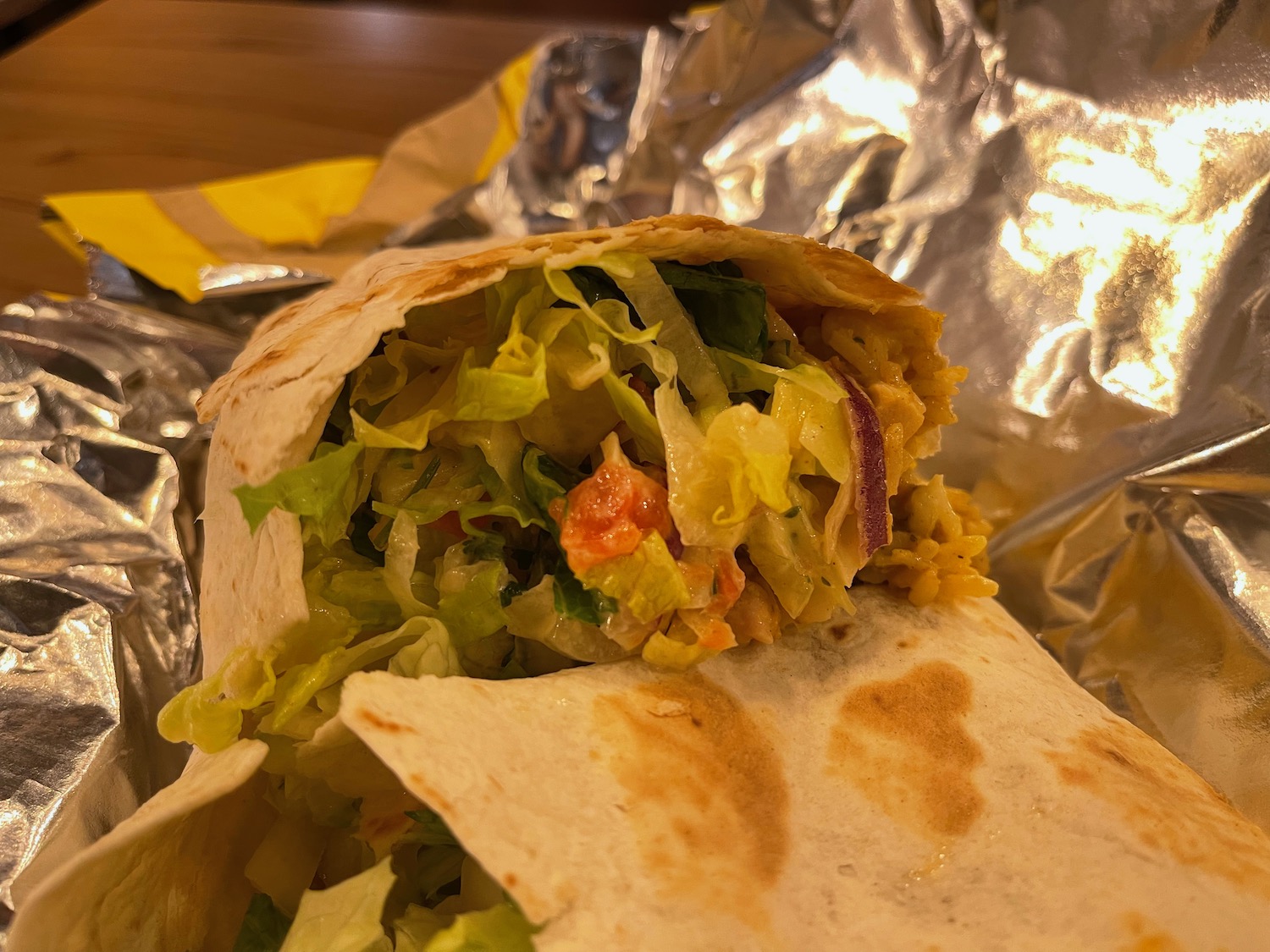 a burrito with lettuce and meat on it