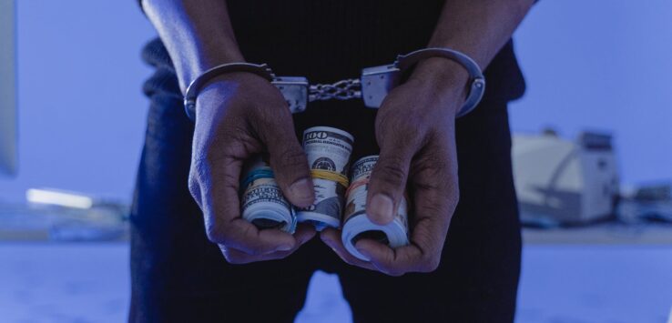 a person in handcuffs holding money