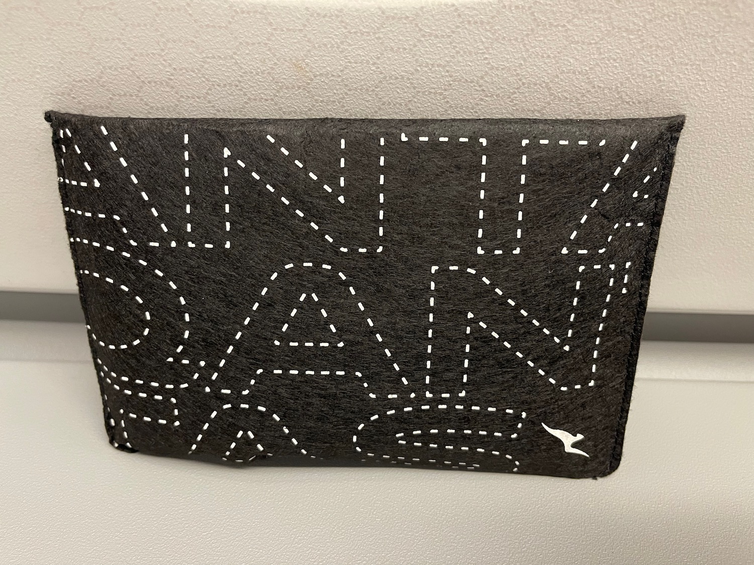a black wallet with white stitching on it
