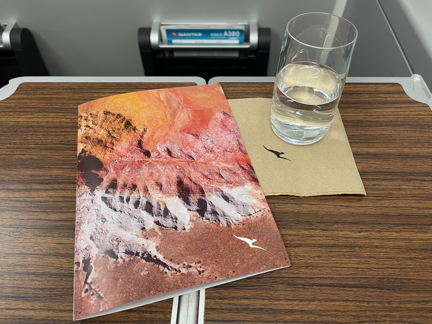 a glass of water next to a book on a table