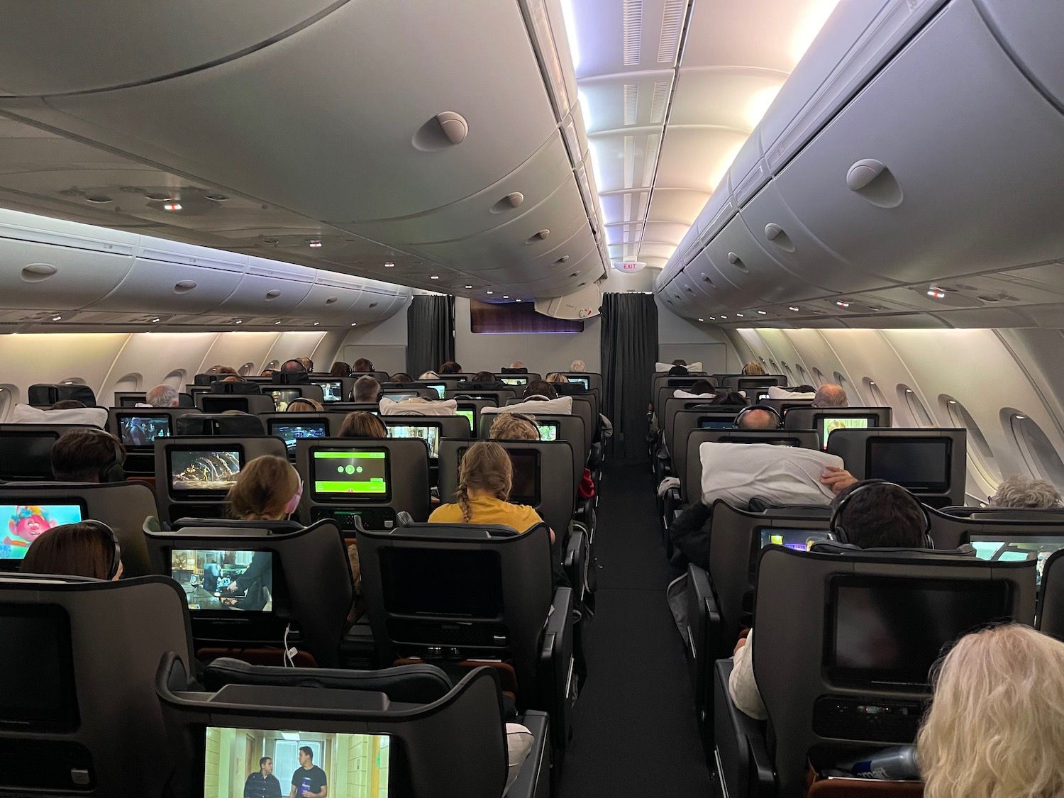 a group of people sitting in chairs with monitors on the seats