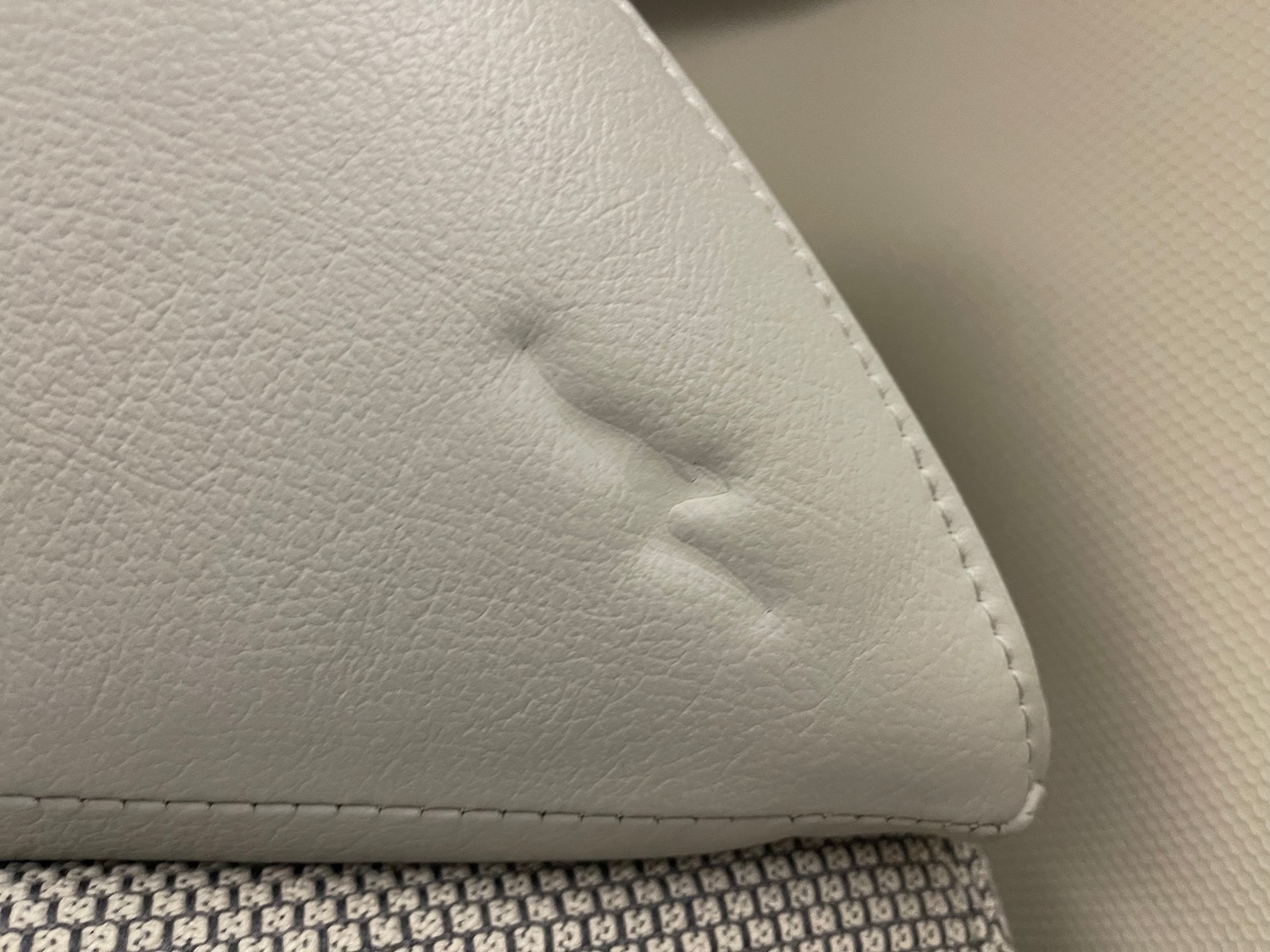 a close up of a white leather surface