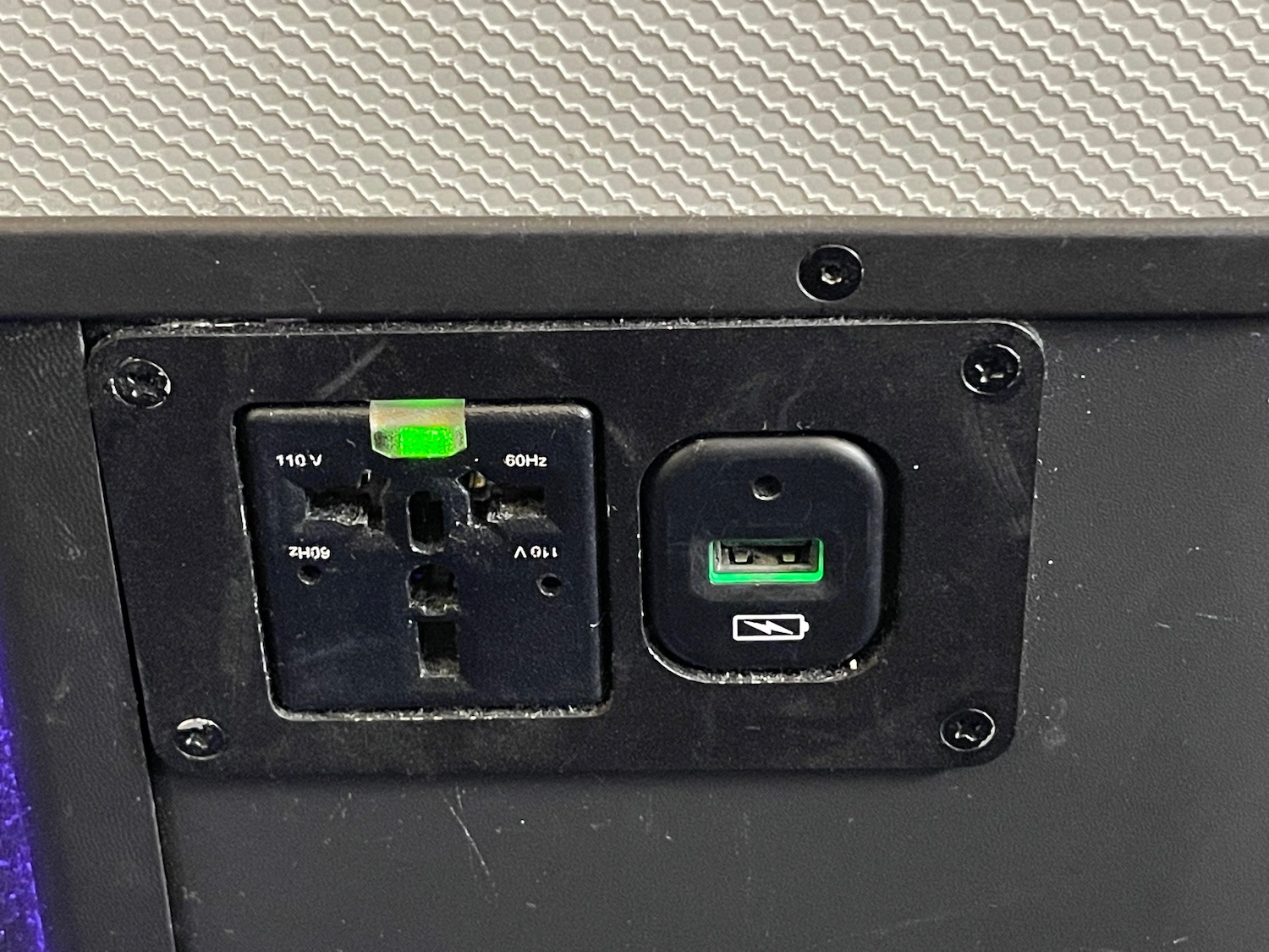 a black rectangular outlet with a green light