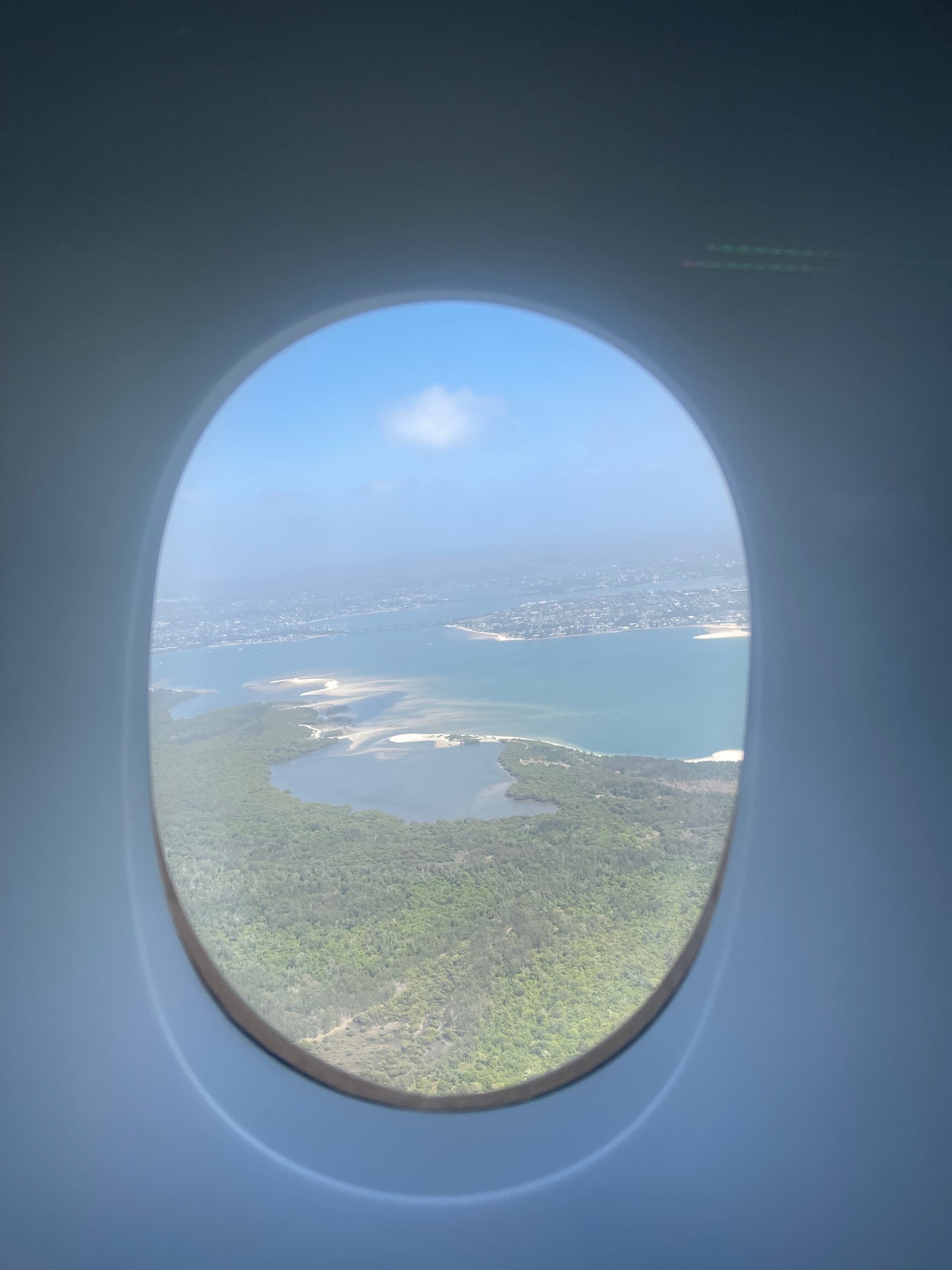 an airplane window with a view of land and water