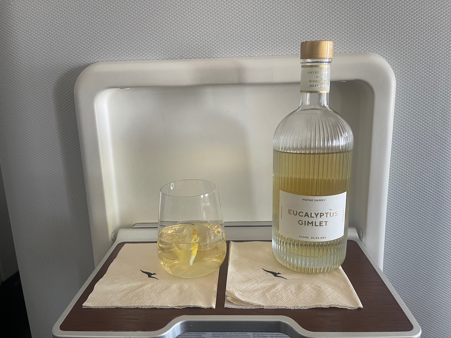 a bottle and glass of liquid on a tray