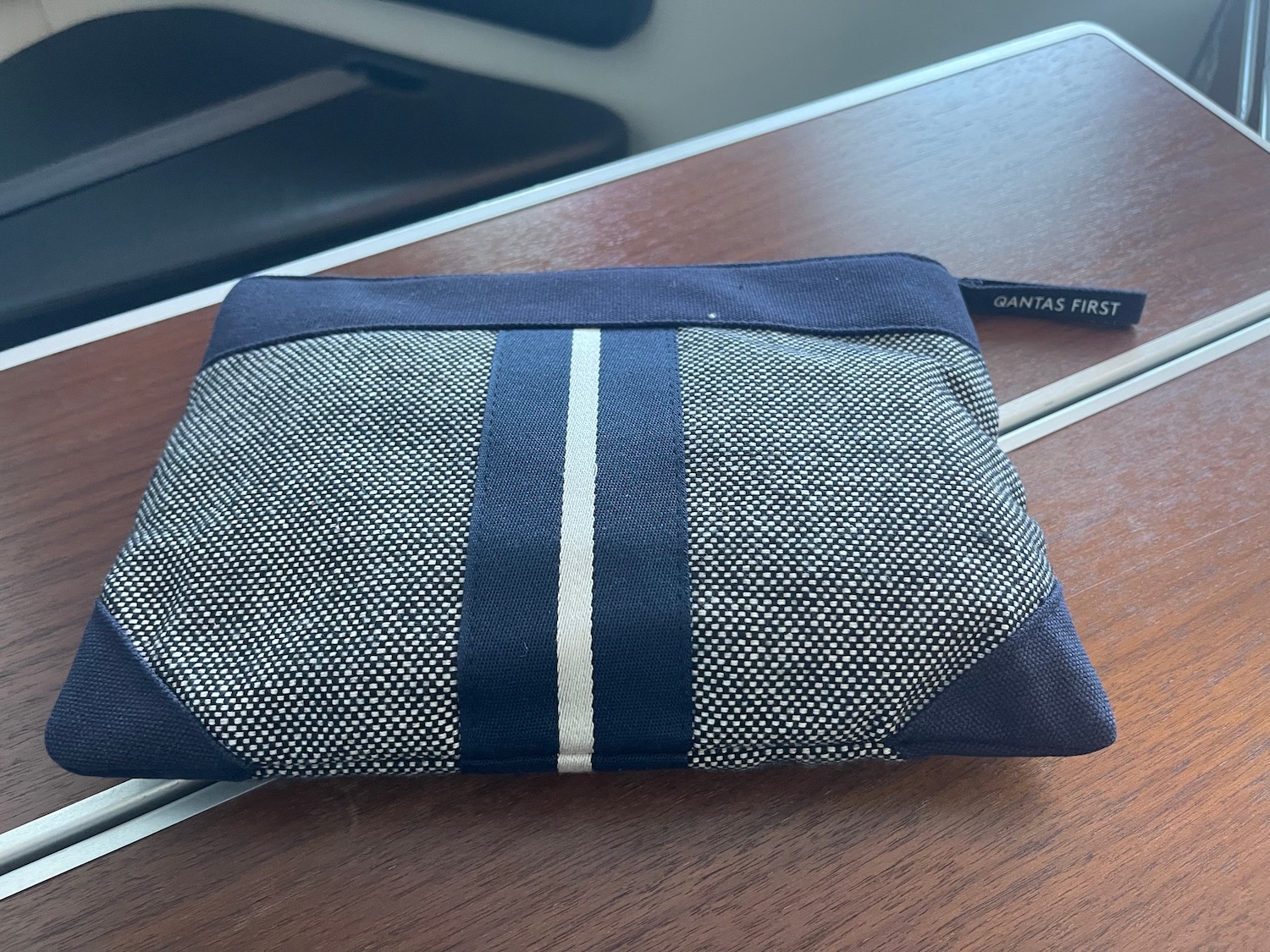 a small blue and white bag on a wood table