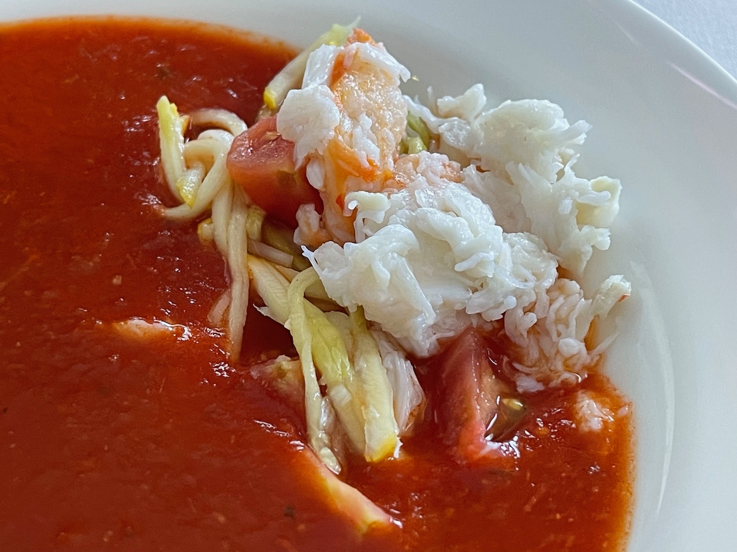 a bowl of soup with crab sticks and noodles