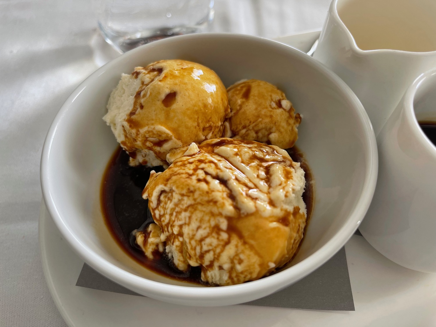 a bowl of ice cream with brown liquid