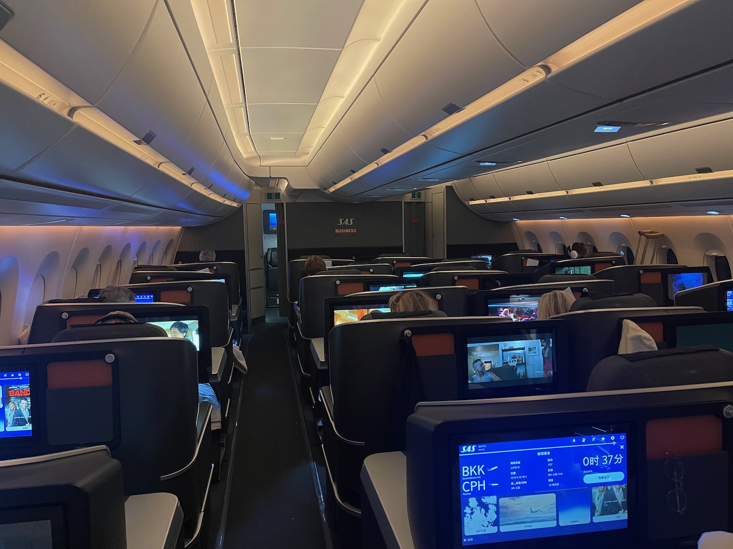 a row of seats with monitors on the back of a plane