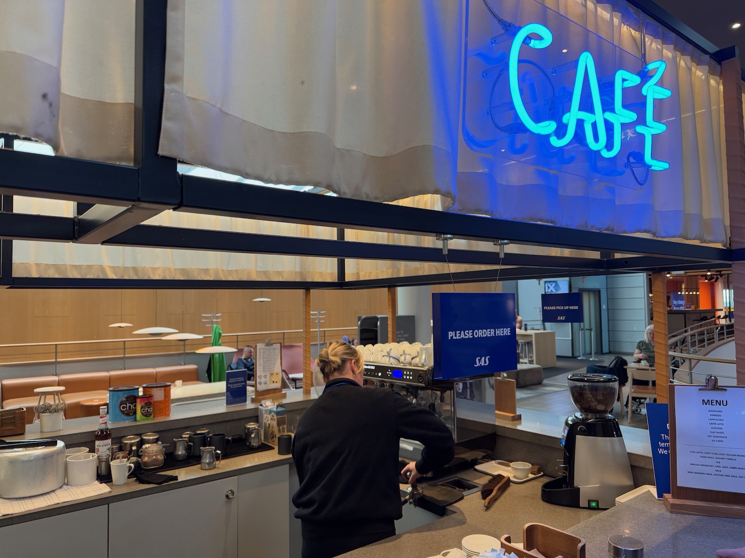 a woman standing at a counter in a cafe
