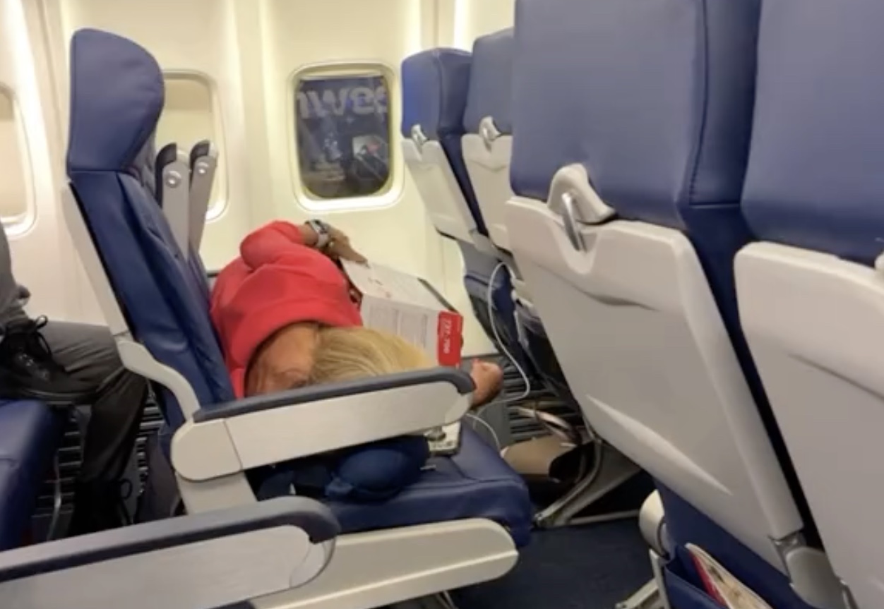 a woman sleeping on an airplane