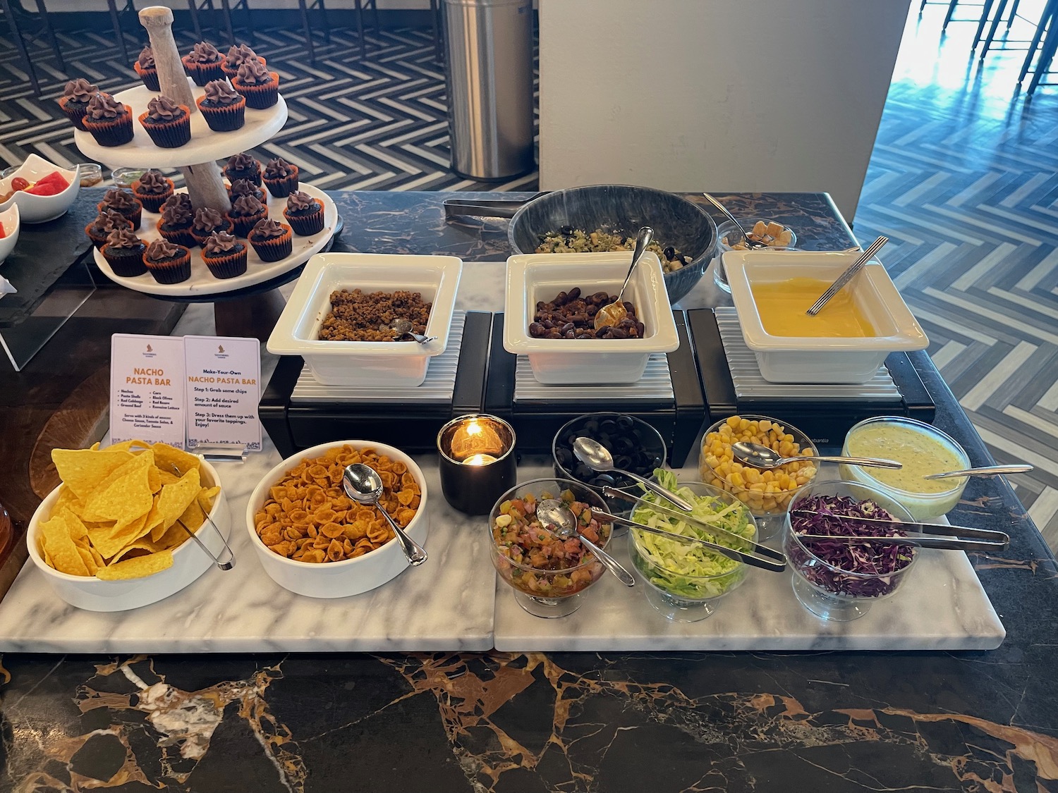 a buffet table with food and cupcakes