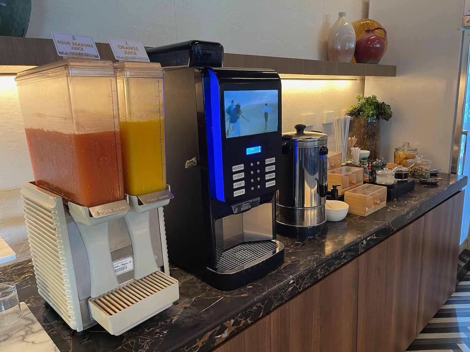 a coffee machine and juice dispensers on a counter