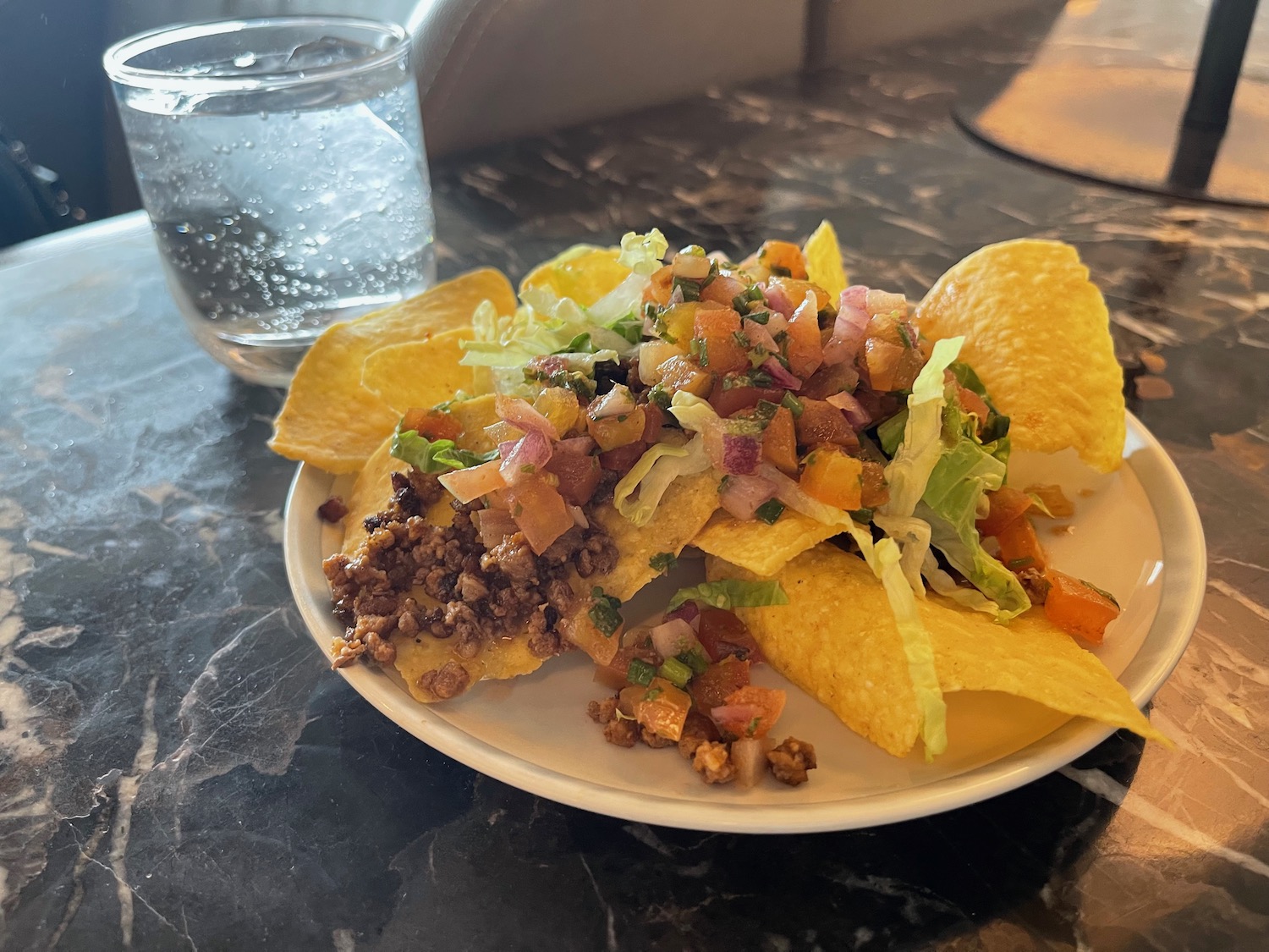 a plate of nachos and a glass of water