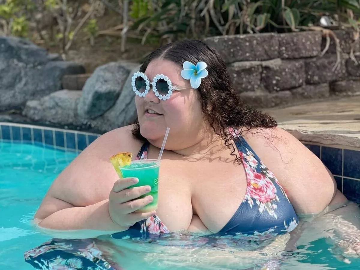 a woman in a swimsuit holding a drink