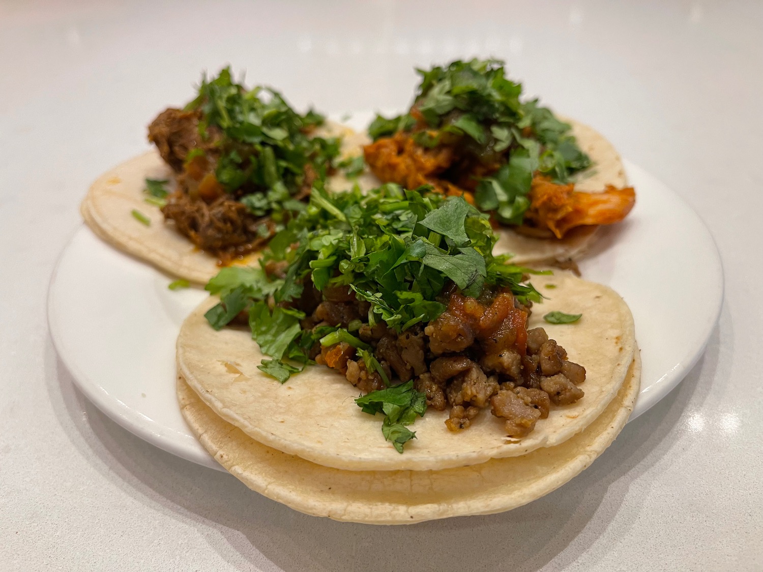 a plate of tacos with meat and greens