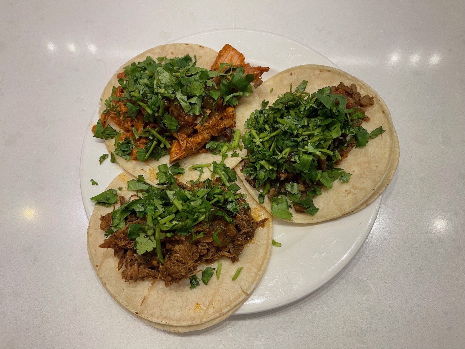 a plate of tacos with meat and cilantro