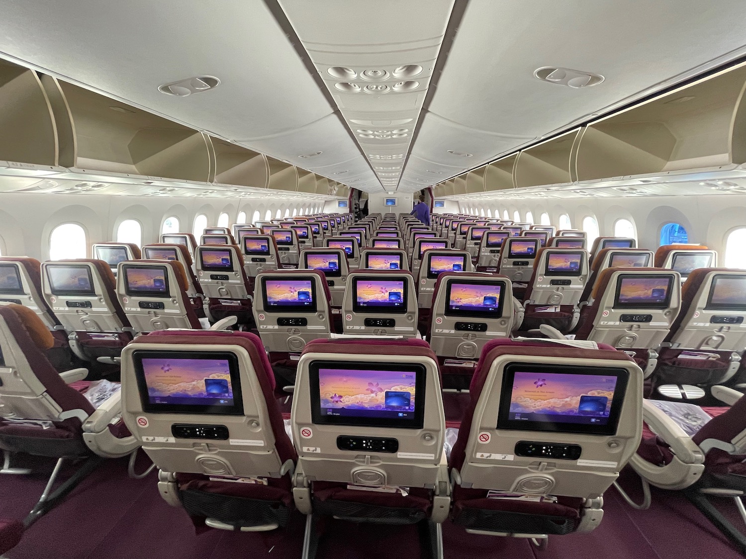 rows of seats with monitors on the side of the plane