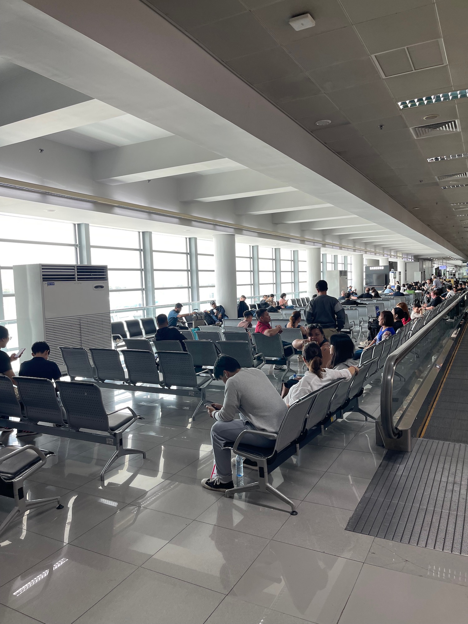 a group of people sitting in chairs in an airport