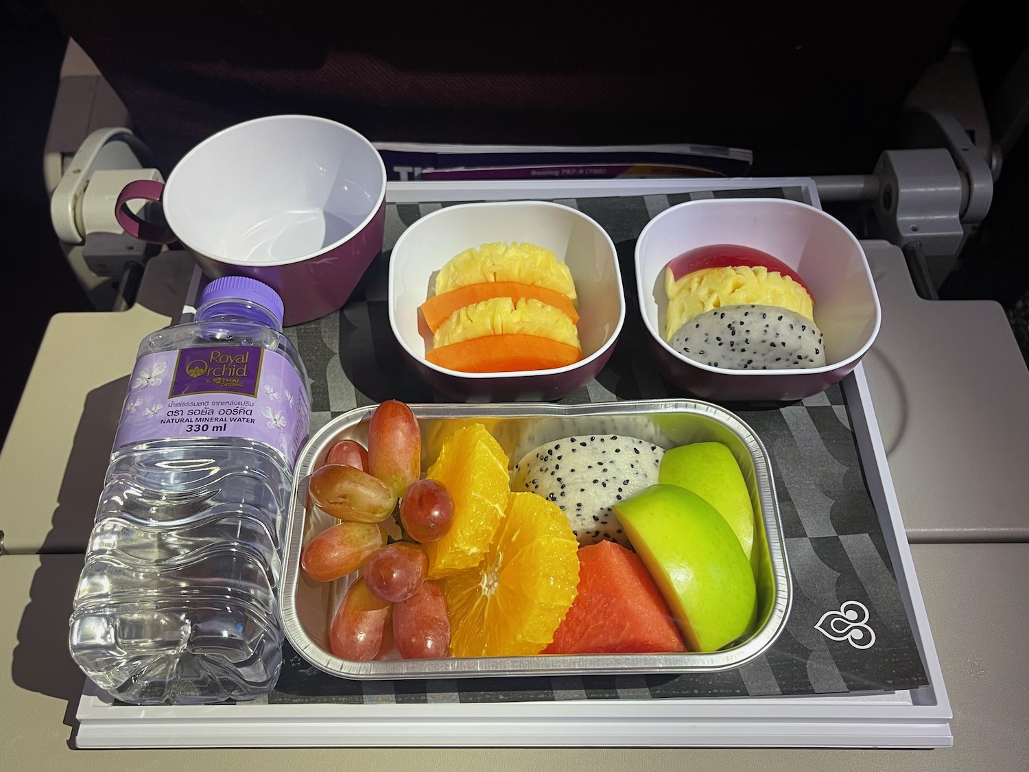 a tray of fruit and a bottle of water on a tray