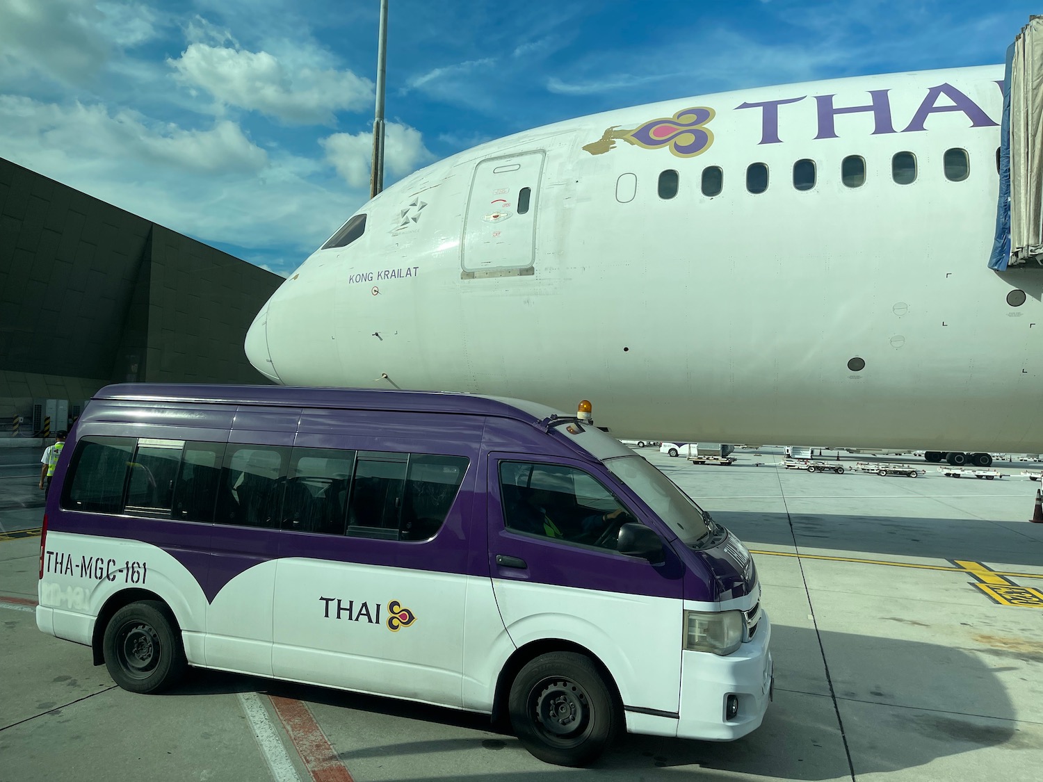a white and purple van next to a large airplane