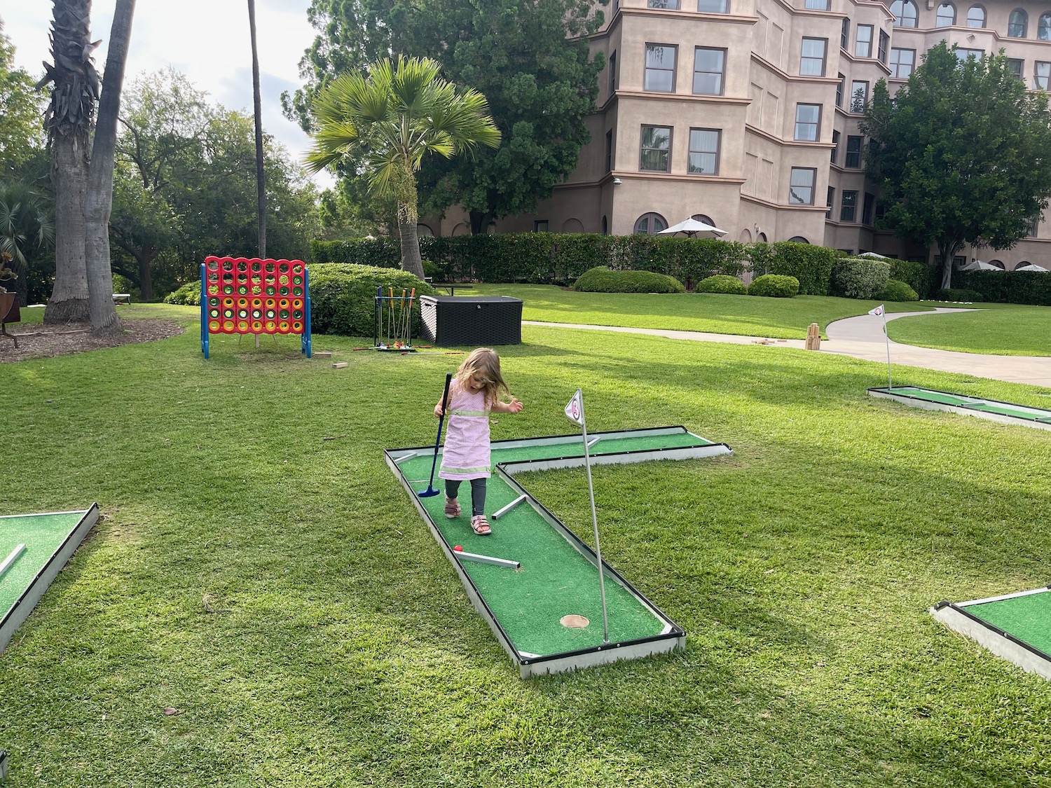 a girl playing mini golf