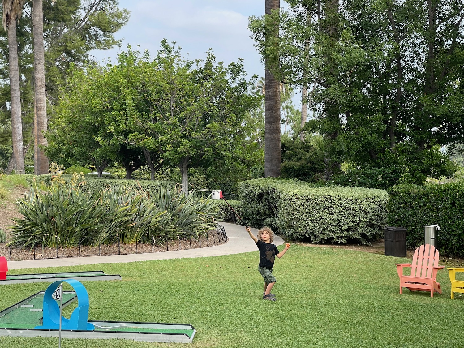 a boy standing on grass in a park