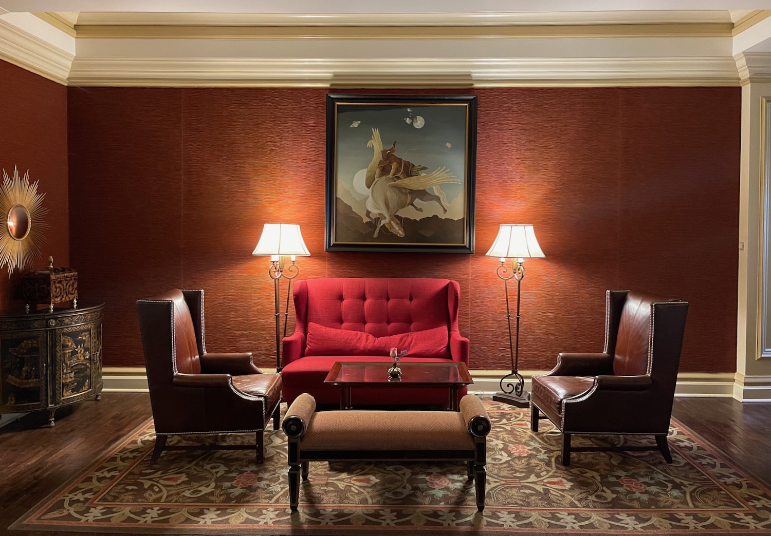 a room with red walls and a red couch and chairs