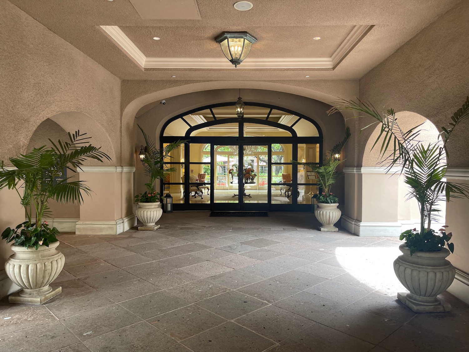 a building with a glass door and plants