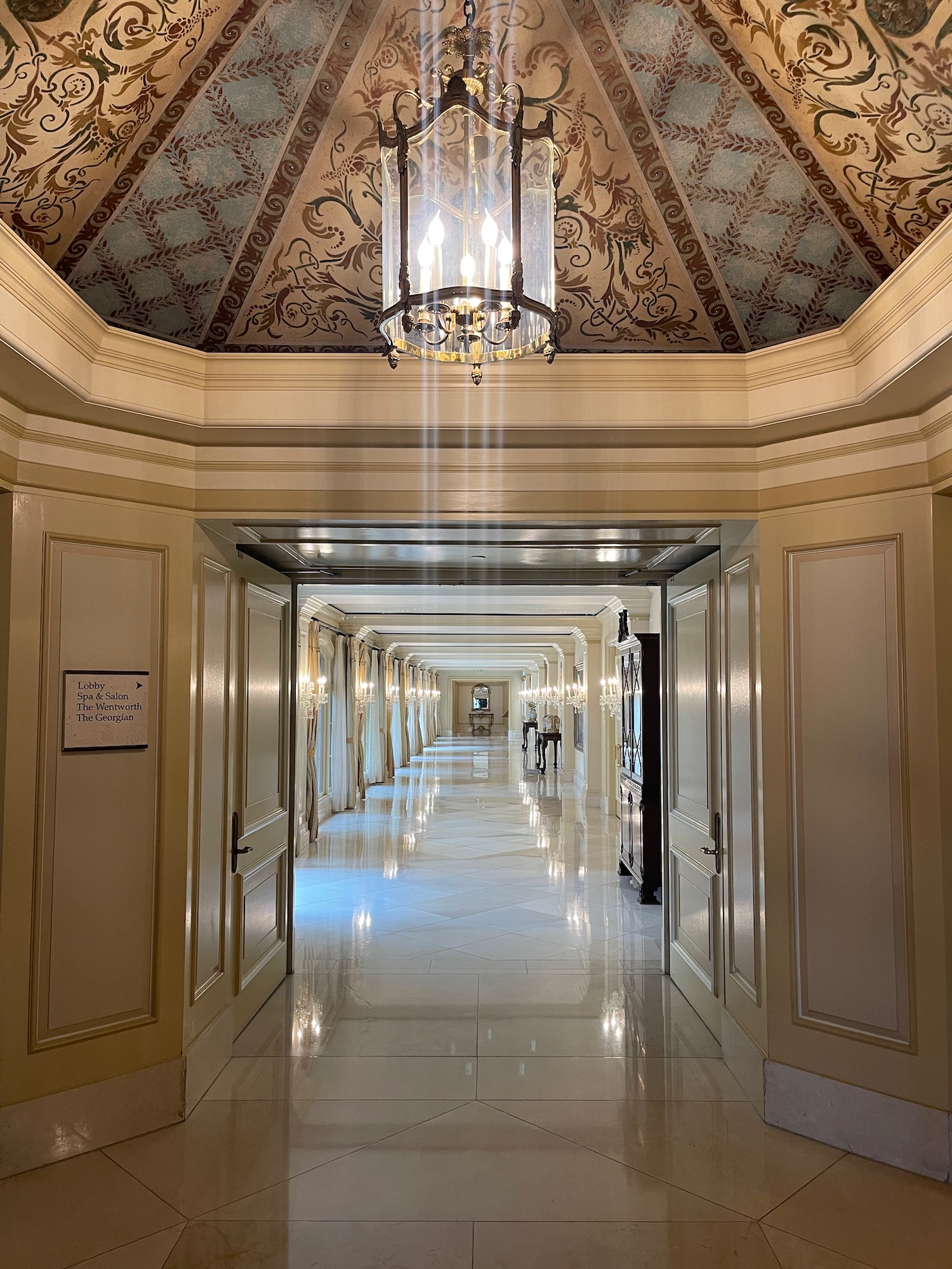 a hallway with a chandelier and ceiling