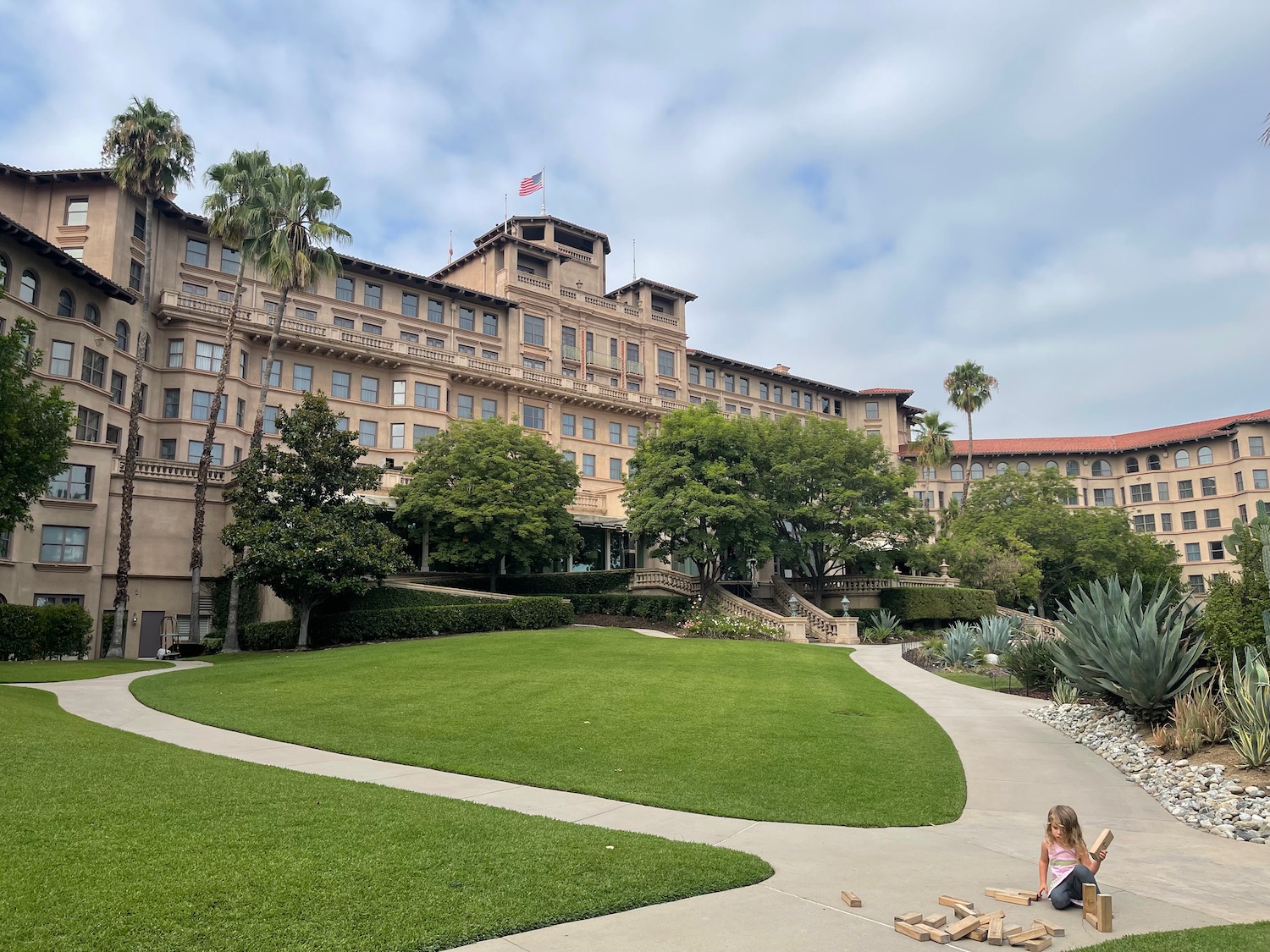 a building with a lawn and a kid playing in front of it