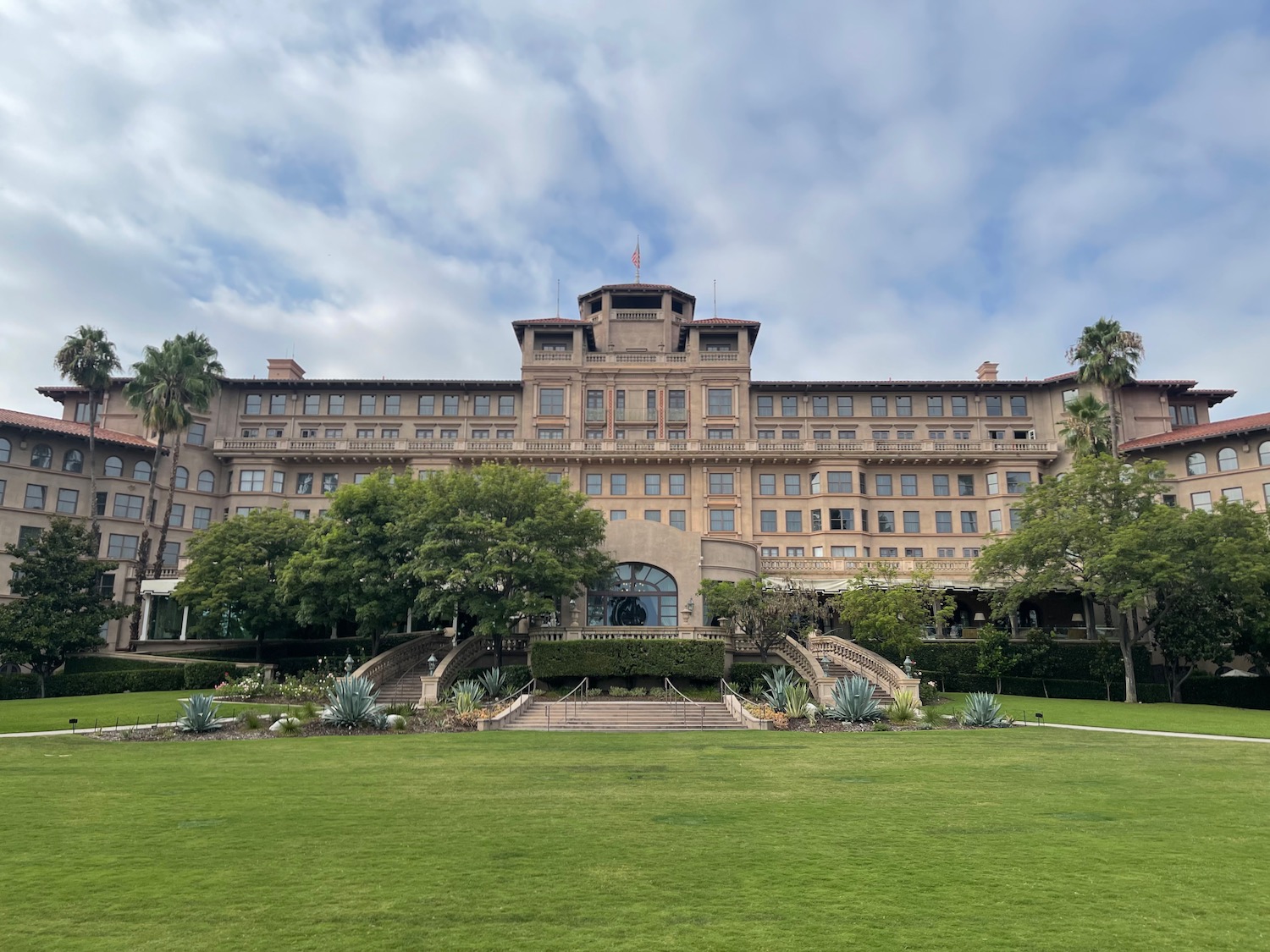 a large building with a lawn and trees