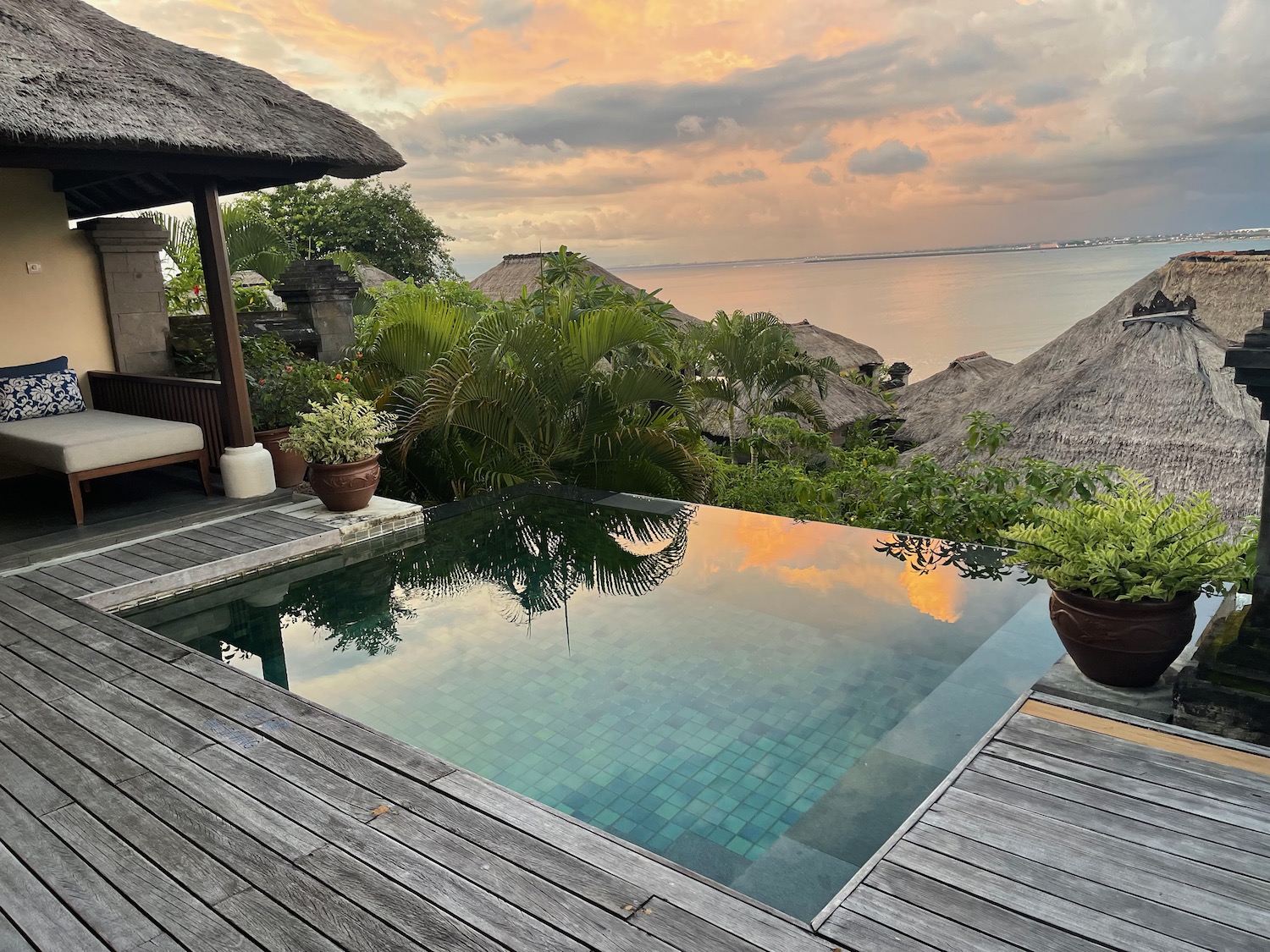 a pool with a thatched roof and a hut