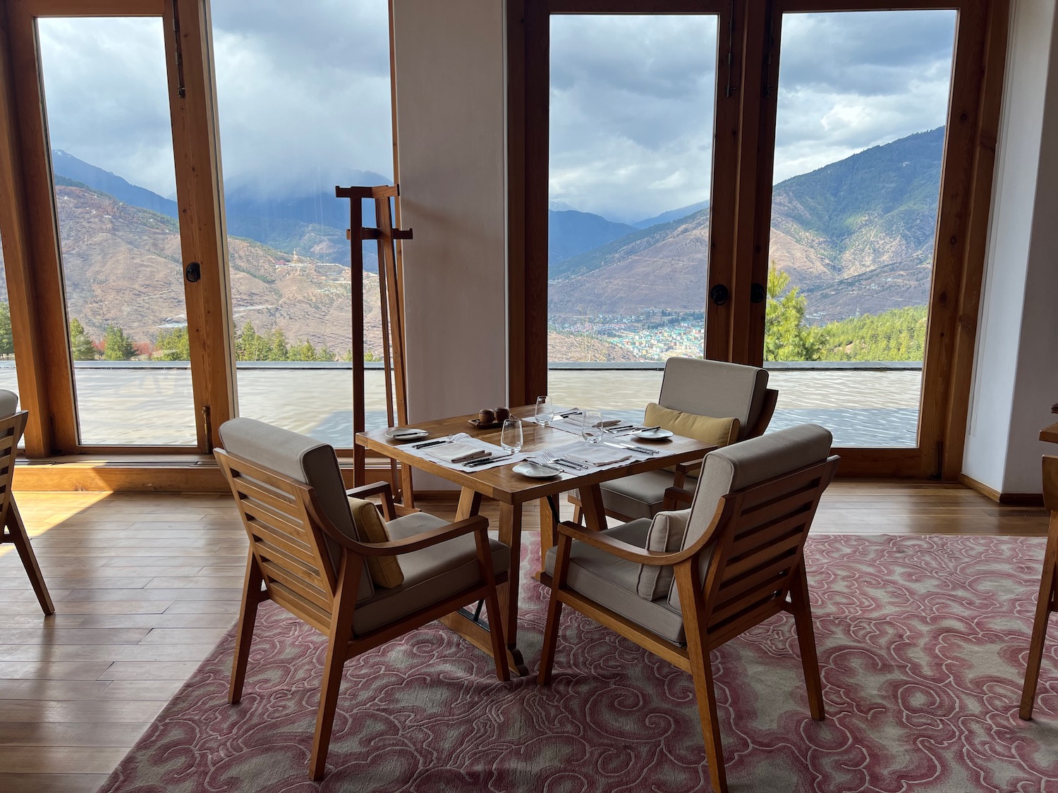 a table and chairs in a room with large windows