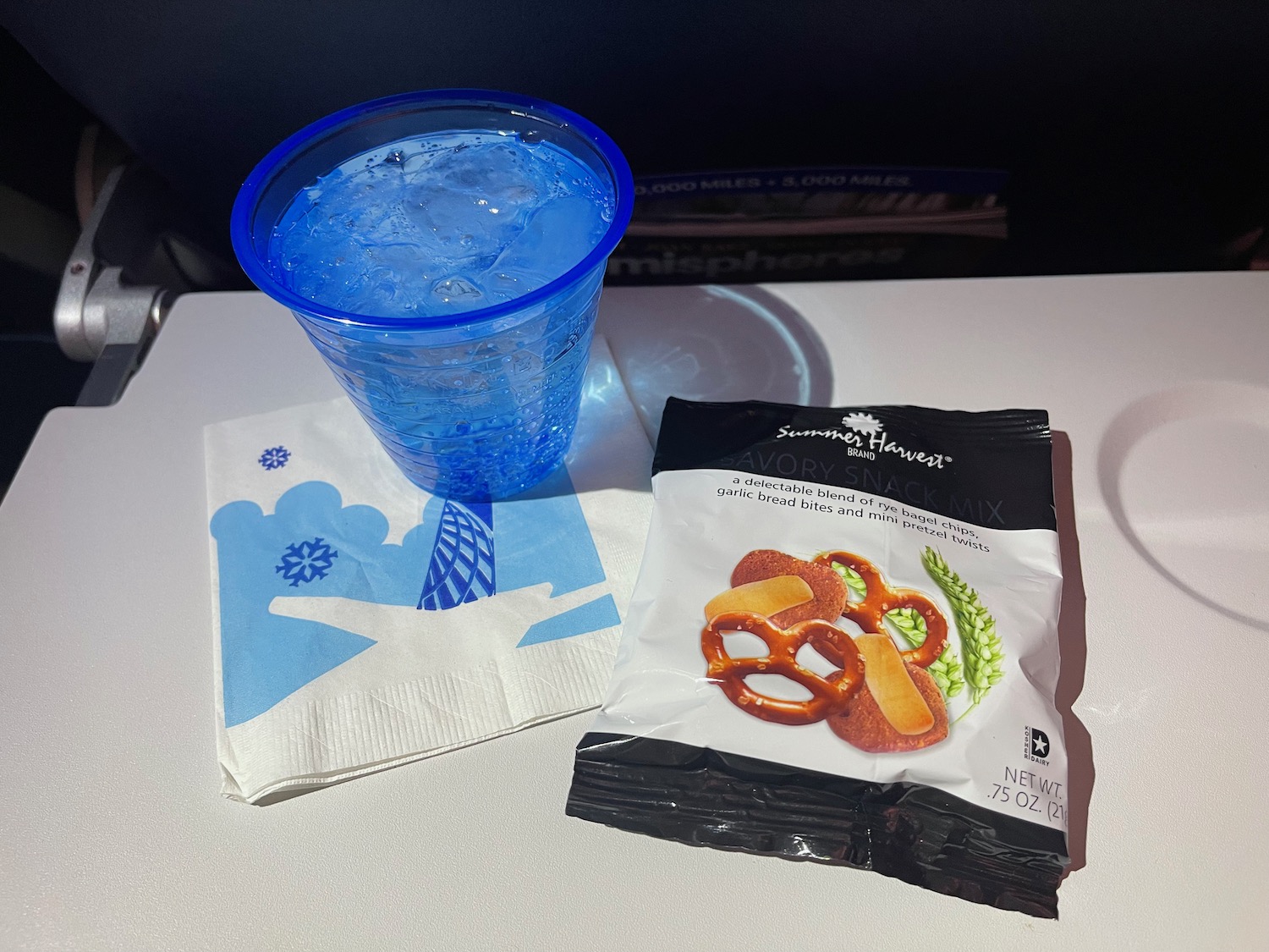a blue cup and a bag of pretzels on a white surface