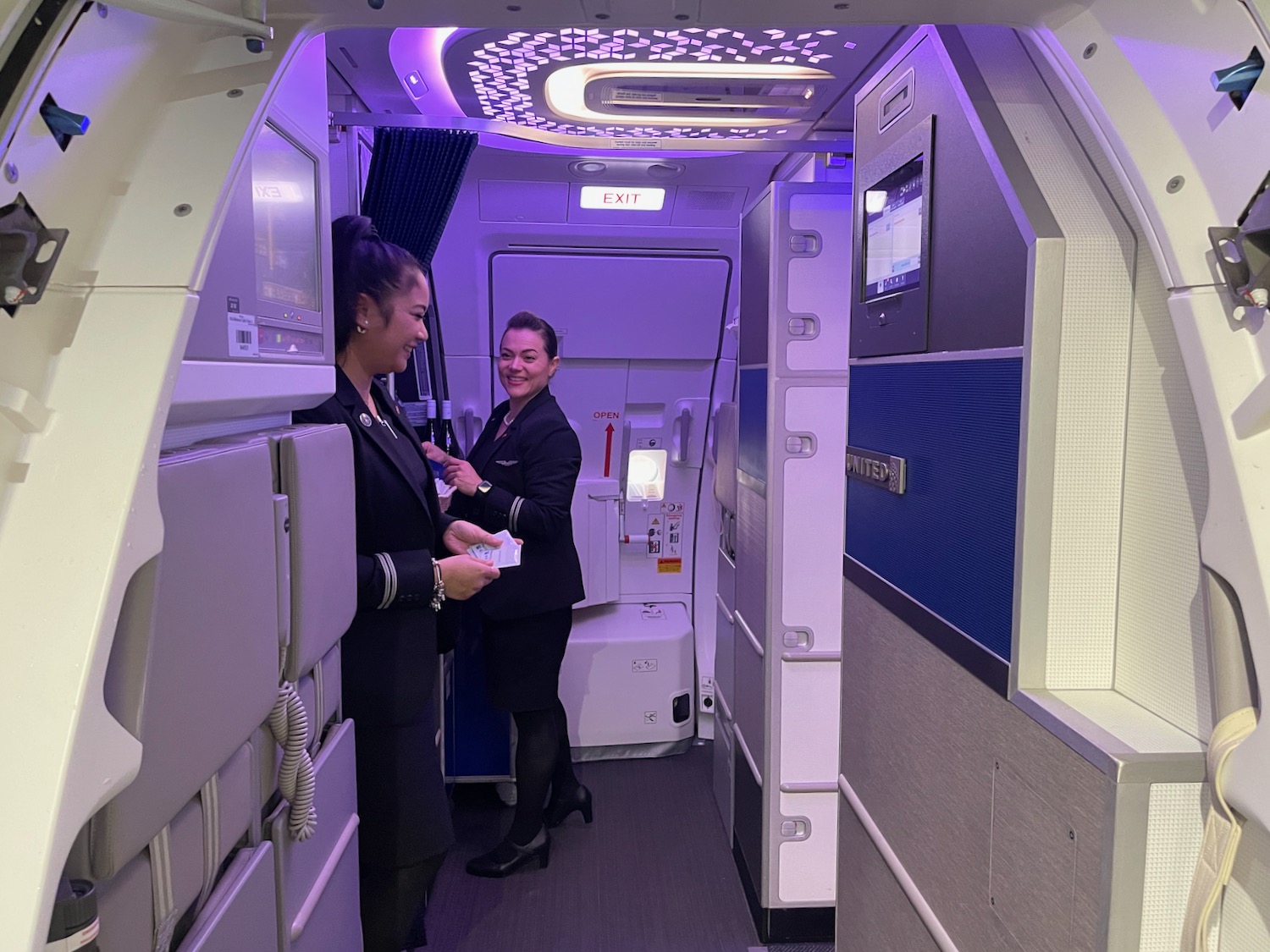 two women in uniform standing in an airplane