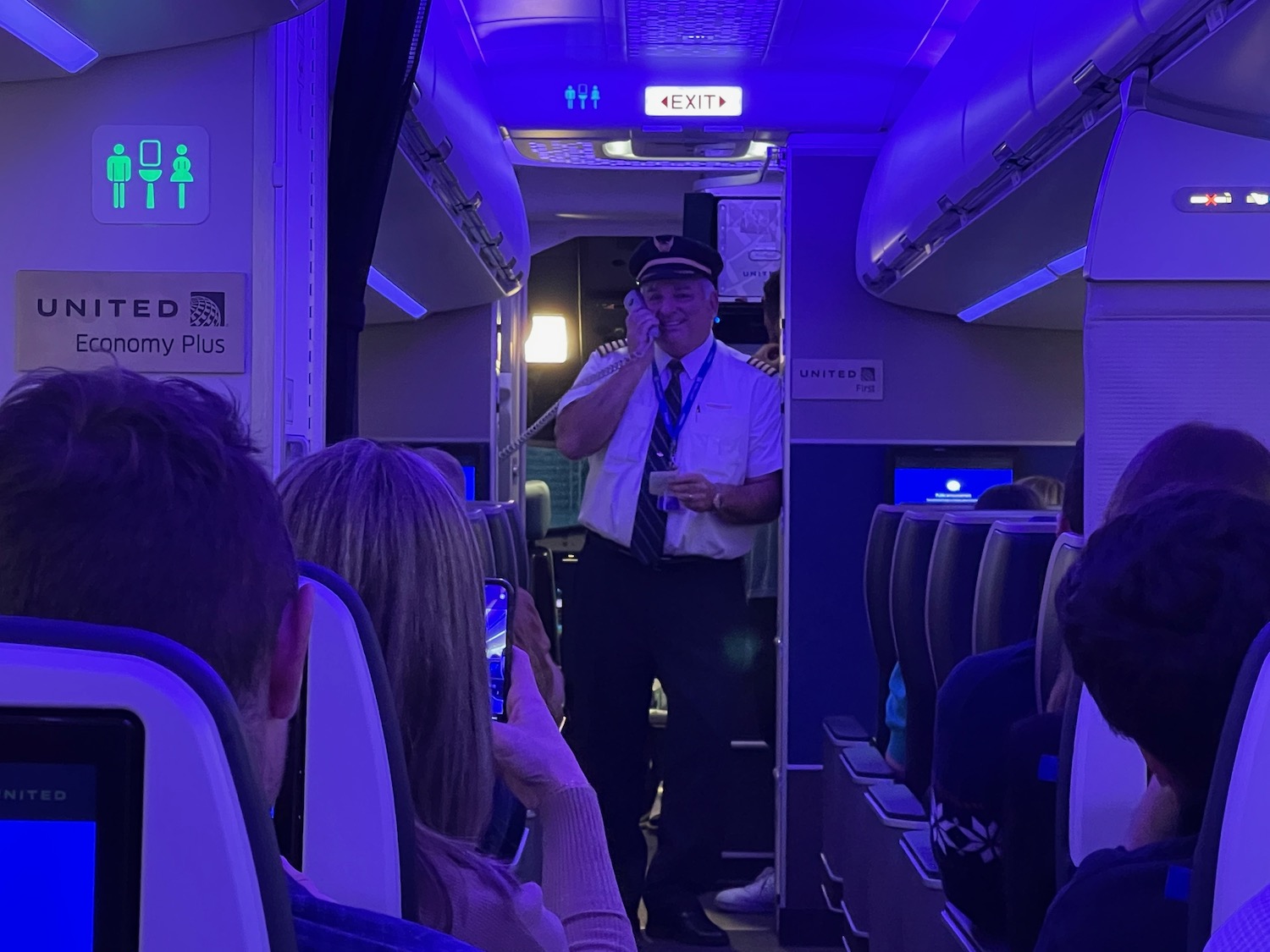 a man in a hat talking on a cell phone in an airplane