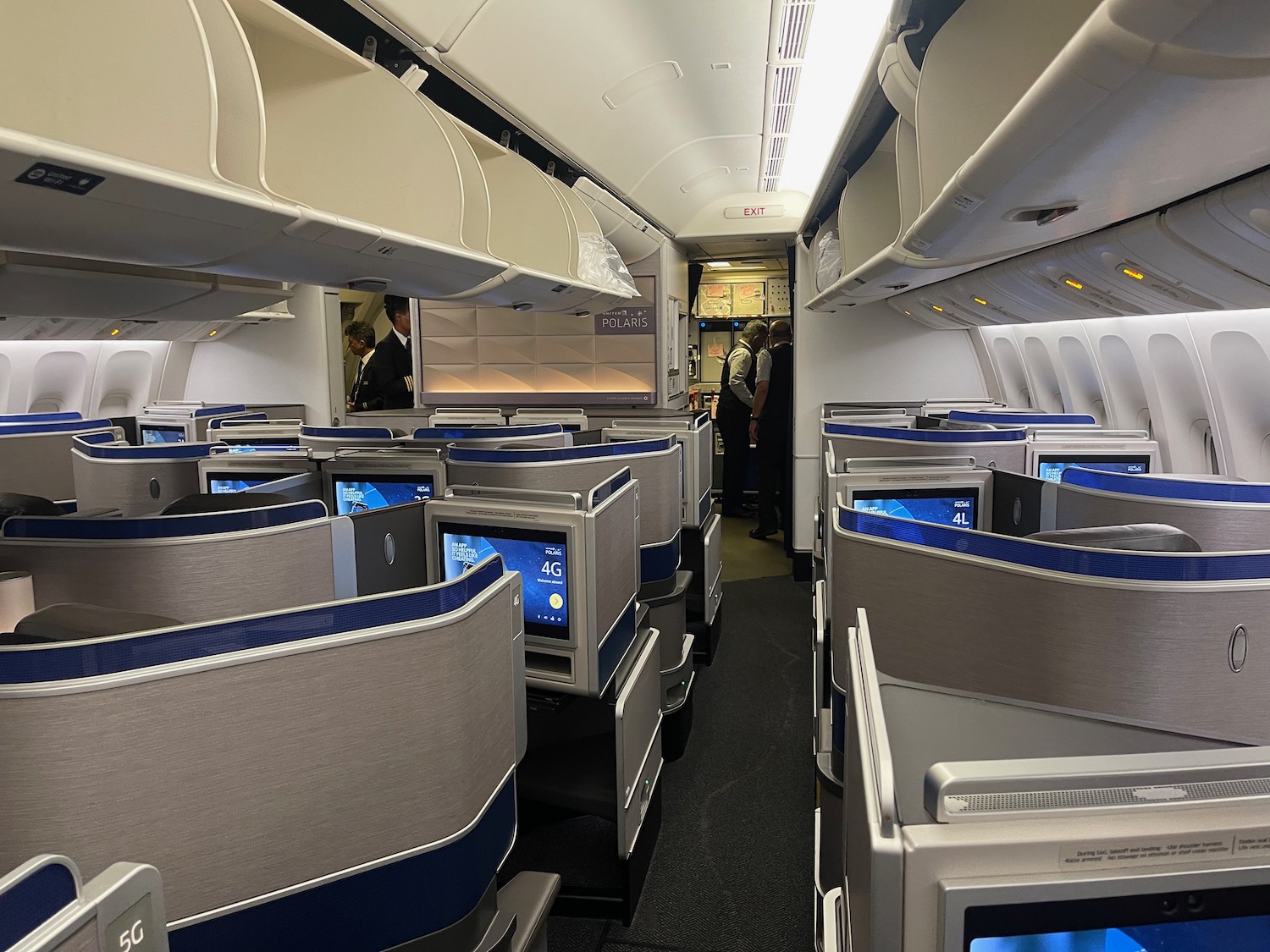 a room with tvs and seats on the side of the plane