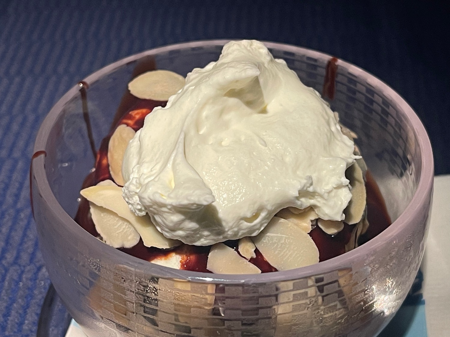 a bowl of ice cream with almonds and chocolate sauce