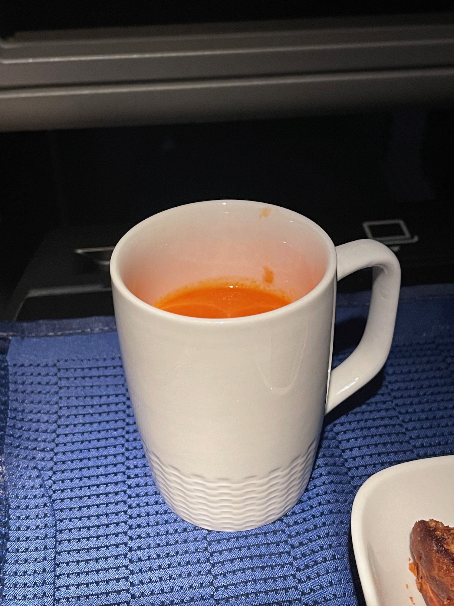 a white mug with orange liquid in it