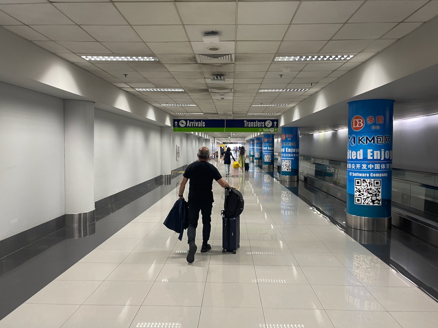 a man pulling luggage in a hallway