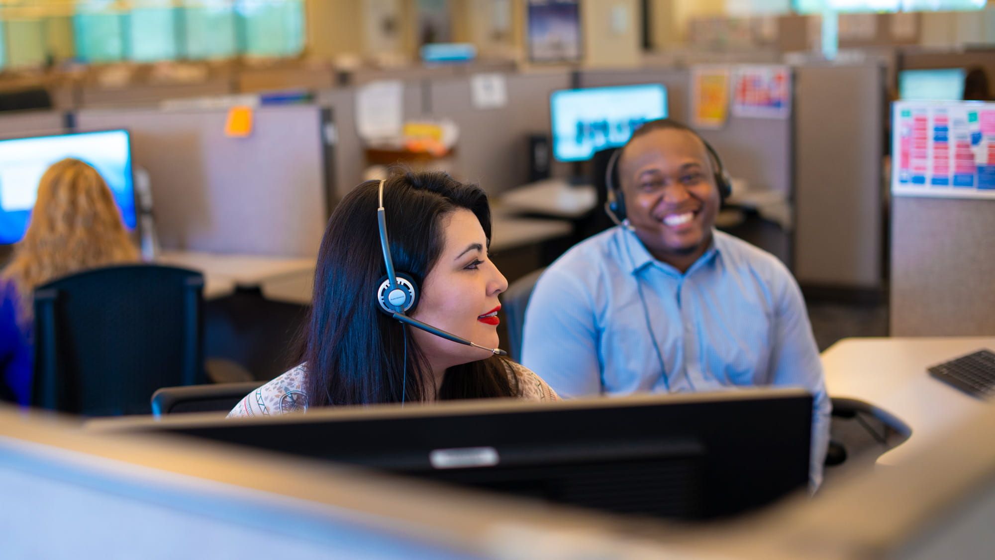 a woman wearing a headset and smiling at a man