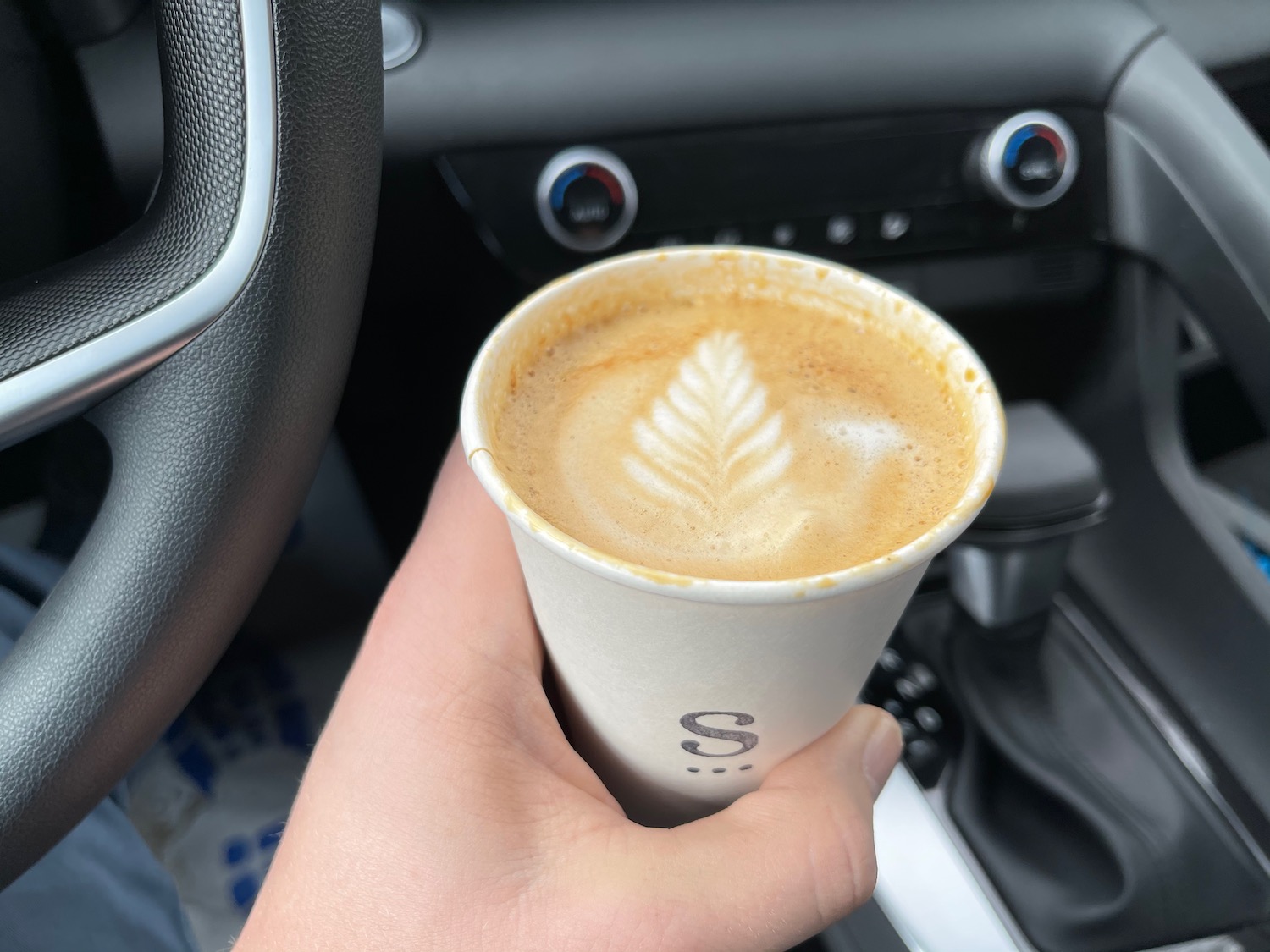 a hand holding a cup of coffee