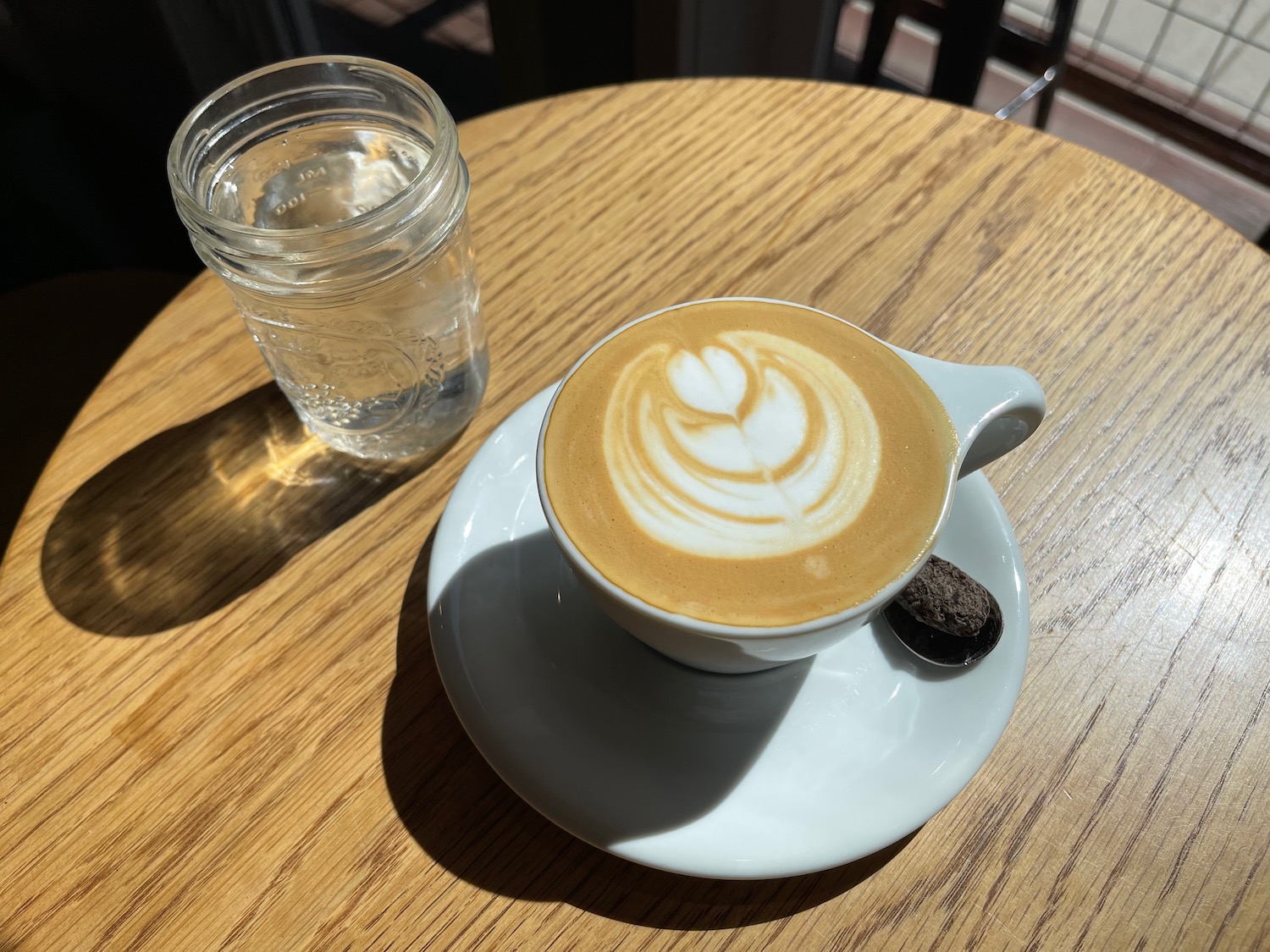 a cup of coffee and a glass of water on a table