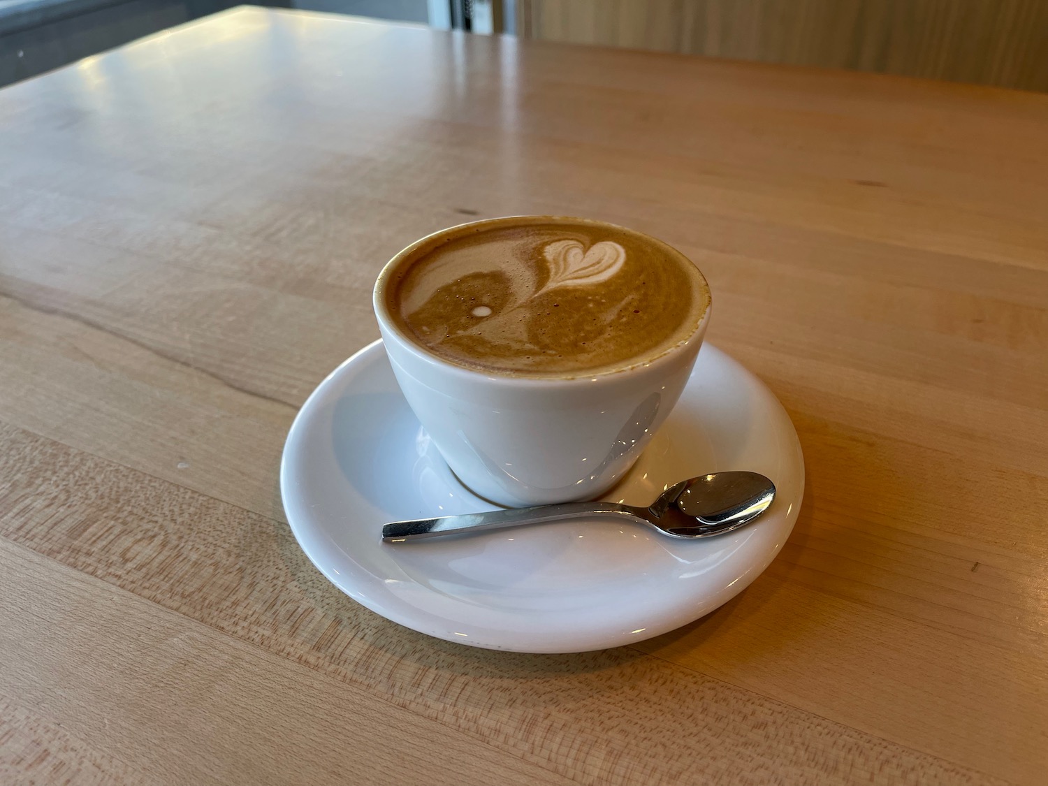 a cup of coffee with a spoon on a saucer